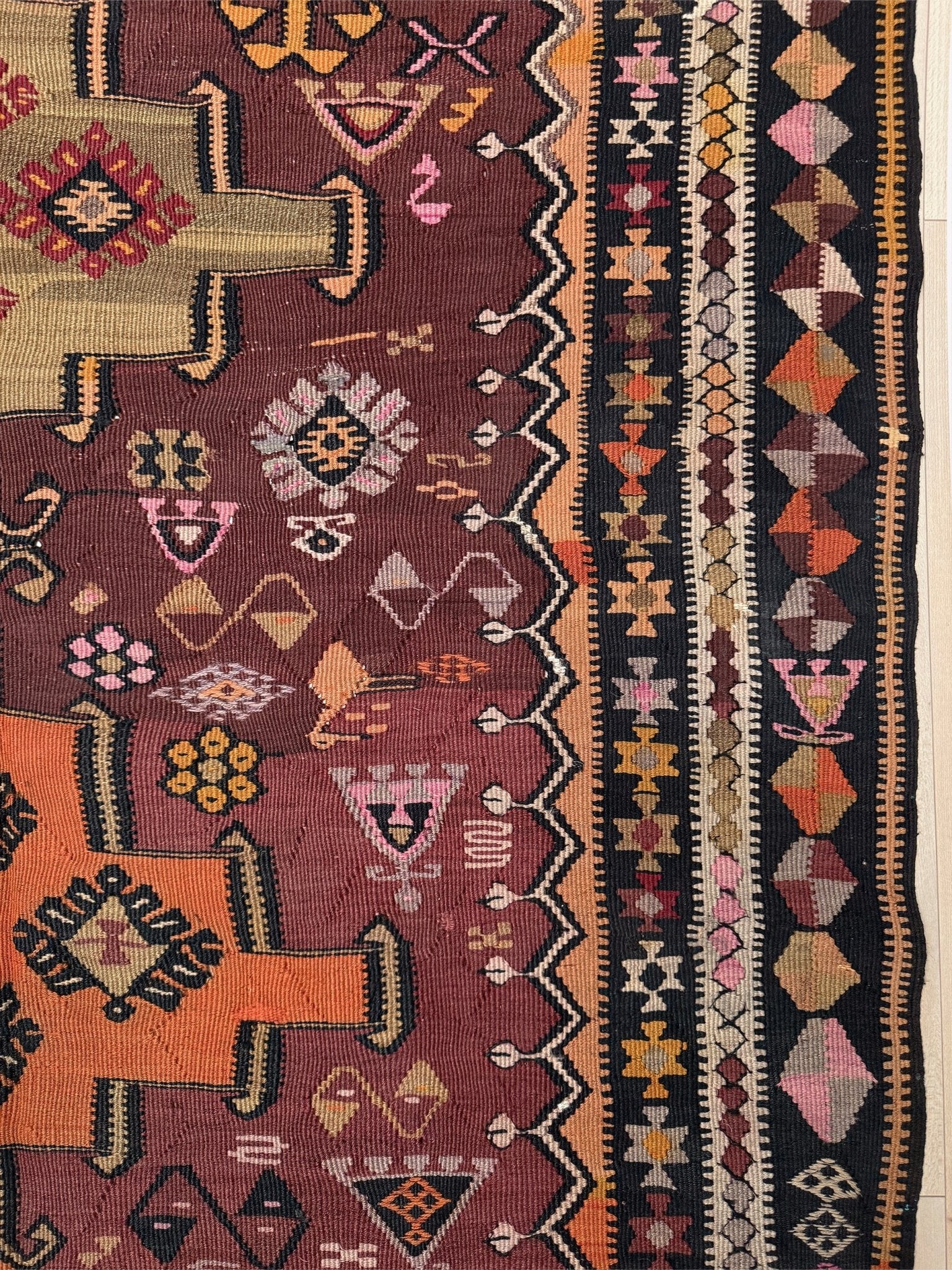 Vintage Kurdish Kars kilim, featuring maroon red and chestnut brown field, geometric medallions, symbolic tribal motifs and protective symbols, handwoven wool 5x10 flatweave rug 