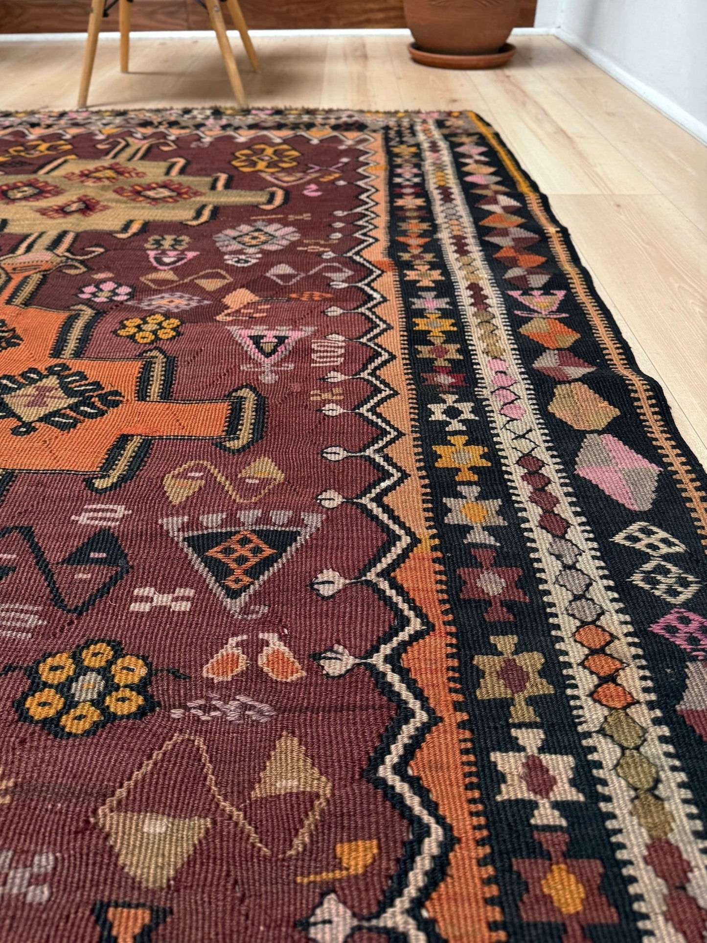 Vintage Kurdish Kars kilim, featuring maroon red and chestnut brown field, geometric medallions, symbolic tribal motifs and protective symbols, handwoven wool 5x10 flatweave rug 