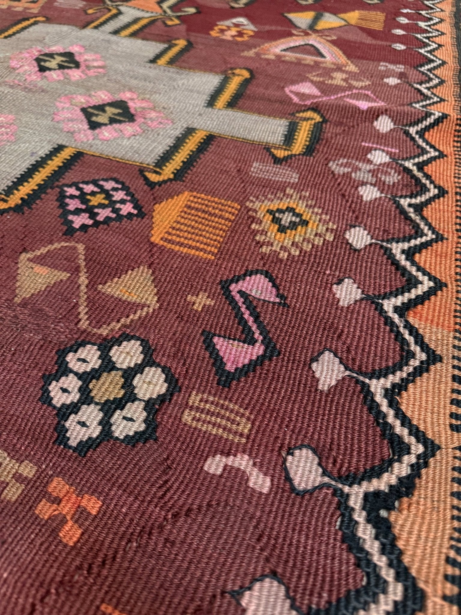 Vintage Kurdish Kars kilim, featuring maroon red and chestnut brown field, geometric medallions, symbolic tribal motifs and protective symbols, handwoven wool 5x10 flatweave rug 