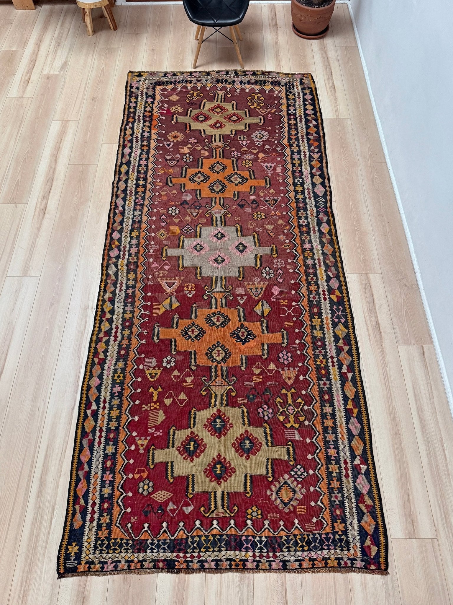 Vintage Kurdish Kars kilim, featuring maroon red and chestnut brown field, geometric medallions, symbolic tribal motifs and protective symbols, handwoven wool 5x10 flatweave rug 