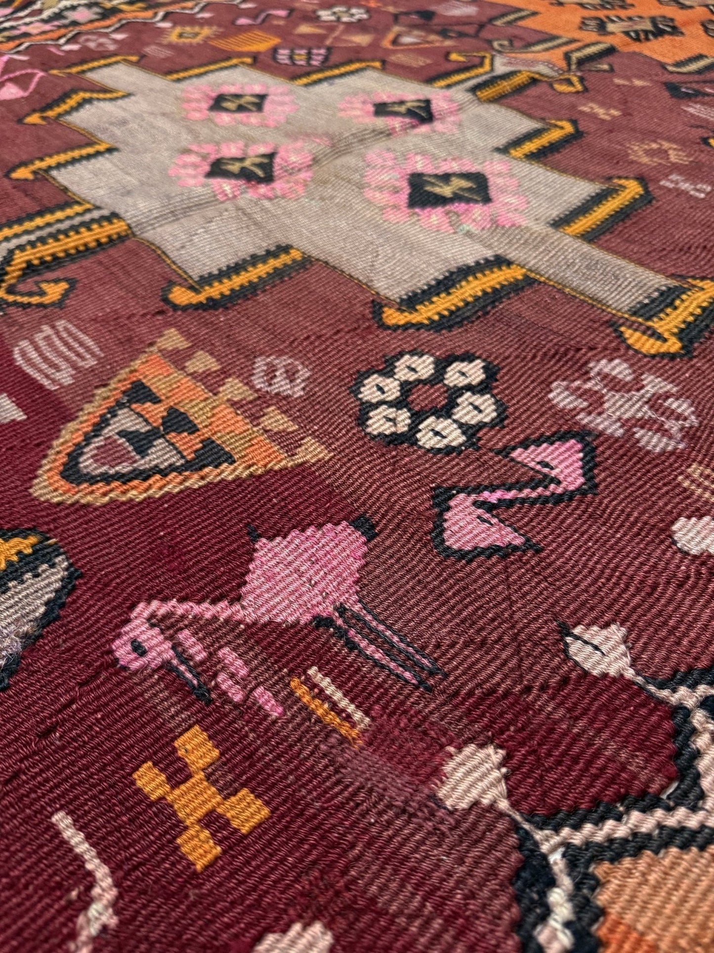 Vintage Kurdish Kars kilim, featuring maroon red and chestnut brown field, geometric medallions, symbolic tribal motifs and protective symbols, handwoven wool 5x10 flatweave rug 