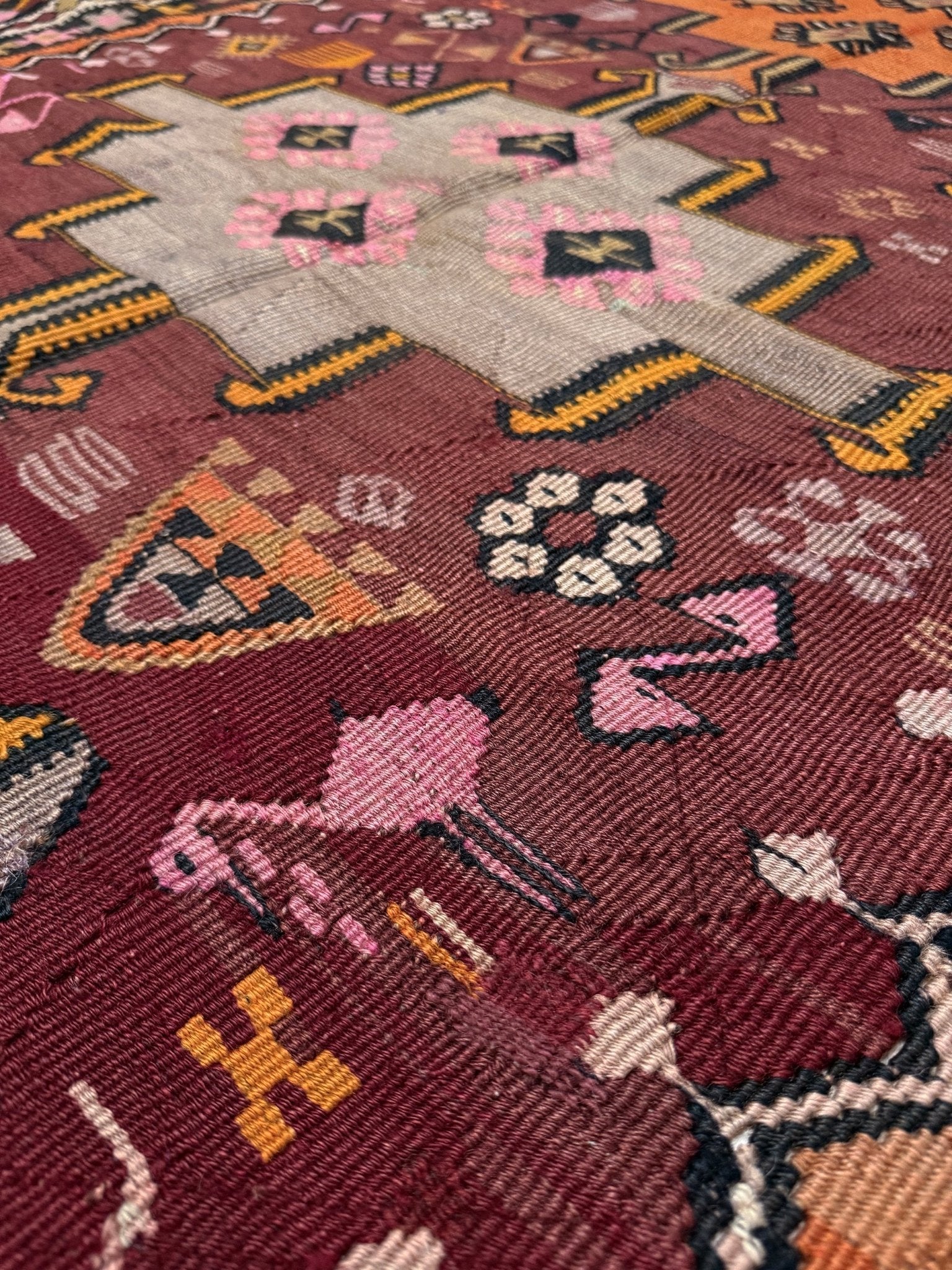 Vintage Kurdish Kars kilim, featuring maroon red and chestnut brown field, geometric medallions, symbolic tribal motifs and protective symbols, handwoven wool 5x10 flatweave rug 