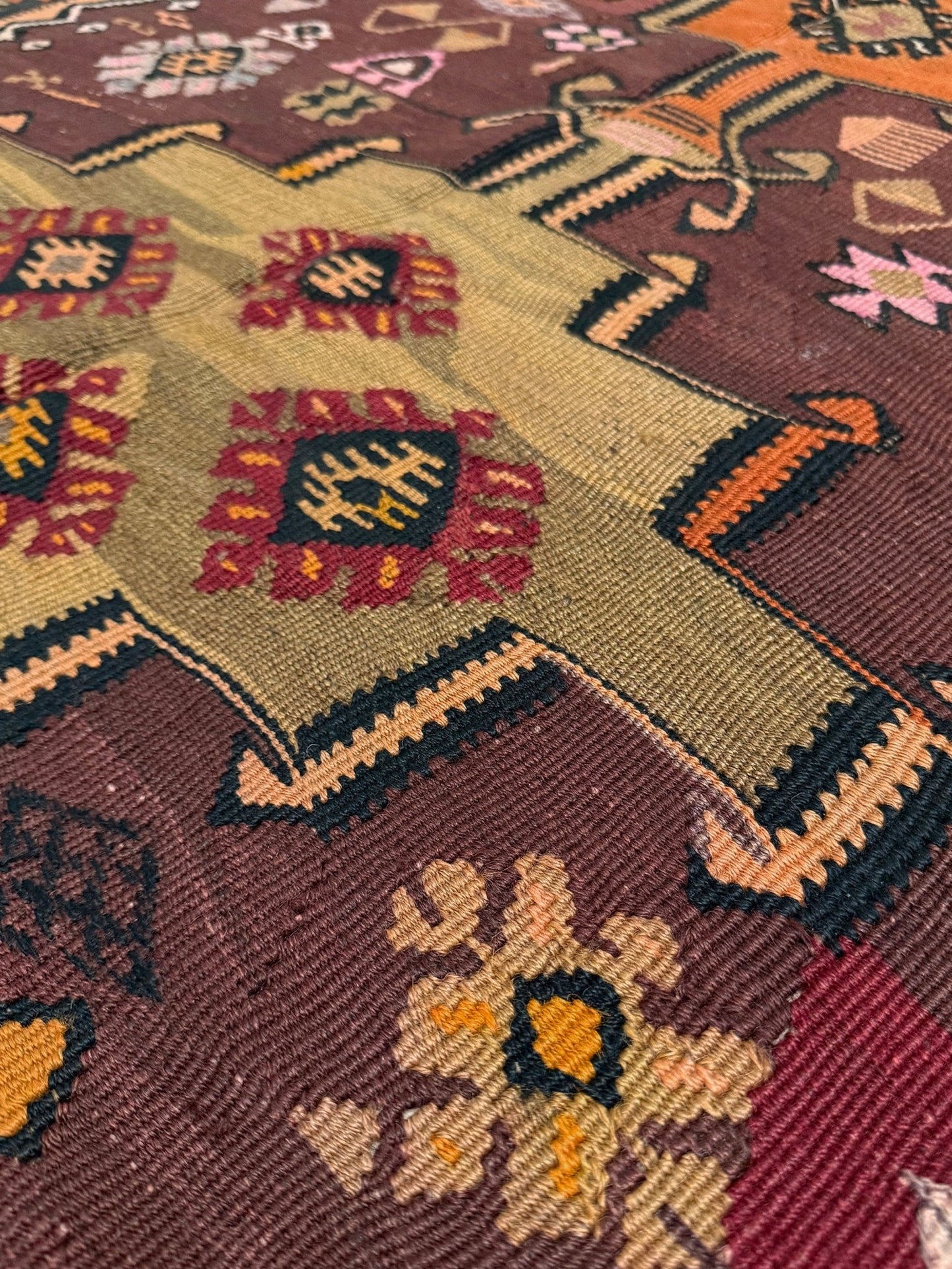 Vintage Kurdish Kars kilim, featuring maroon red and chestnut brown field, geometric medallions, symbolic tribal motifs and protective symbols, handwoven wool 5x10 flatweave rug 