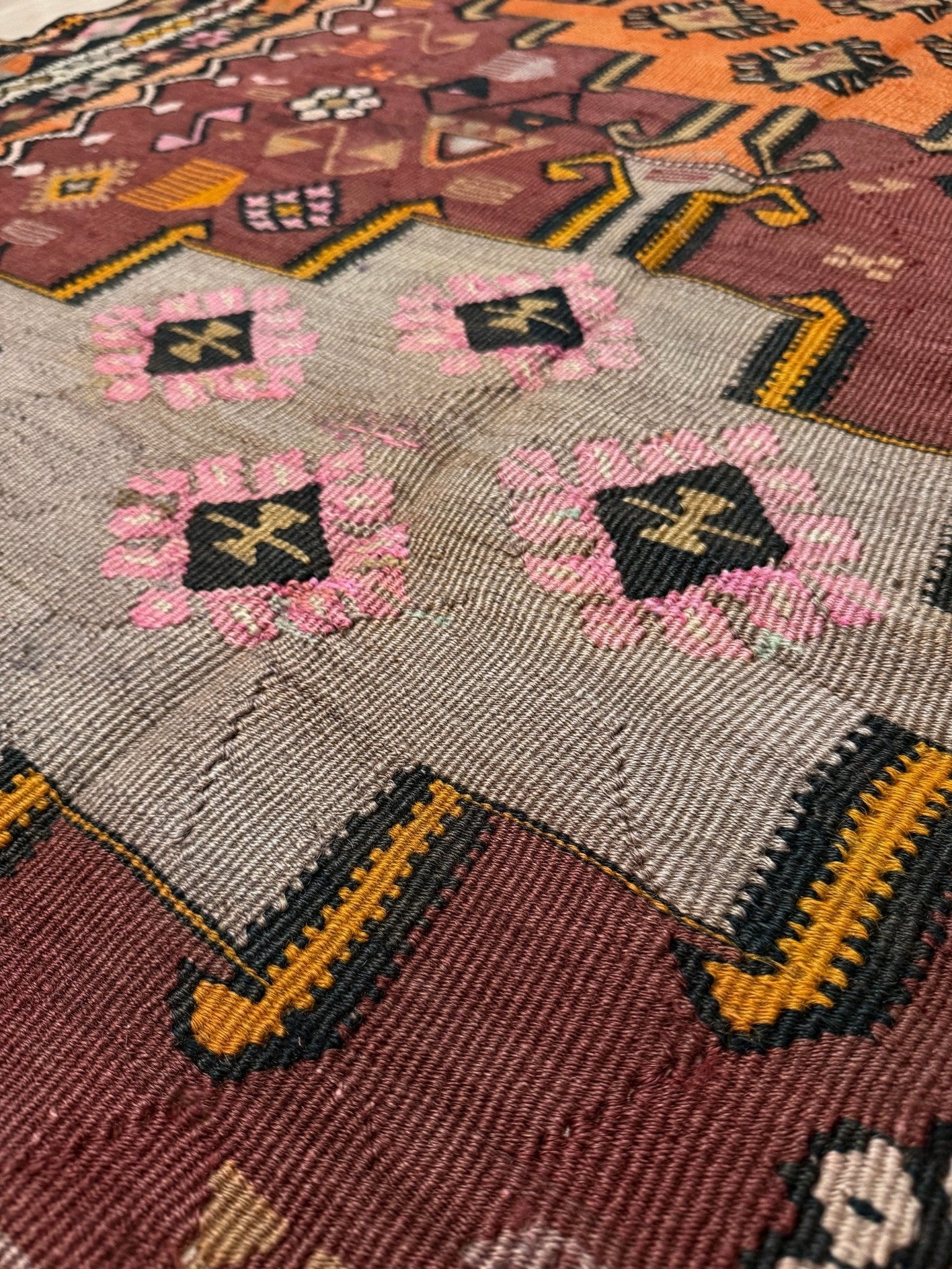Vintage Kurdish Kars kilim, featuring maroon red and chestnut brown field, geometric medallions, symbolic tribal motifs and protective symbols, handwoven wool 5x10 flatweave rug 
