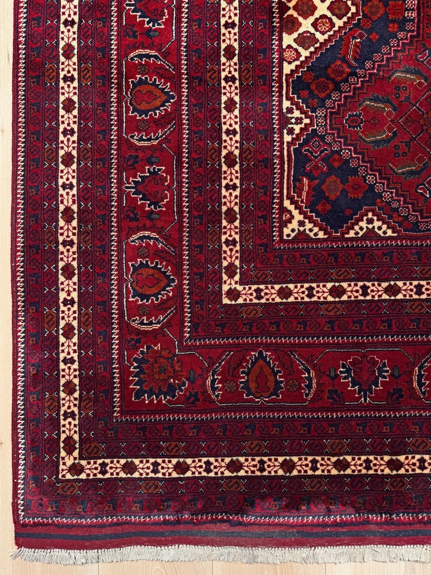 Deep crimson Khal Mohammadi Afghan rug with classic Turkmen gul medallions, dark navy border, ivory details, burgundy, terracotta, beige and forest green accents, handmade Merino wool 10x14 from Indigo Rugs Burlingame Bay Area.