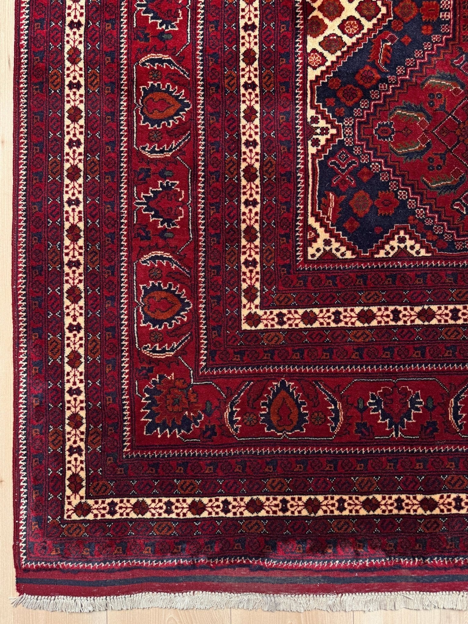 Deep crimson Khal Mohammadi Afghan rug with classic Turkmen gul medallions, dark navy border, ivory details, burgundy, terracotta, beige and forest green accents, handmade Merino wool 10x14 from Indigo Rugs Burlingame Bay Area.