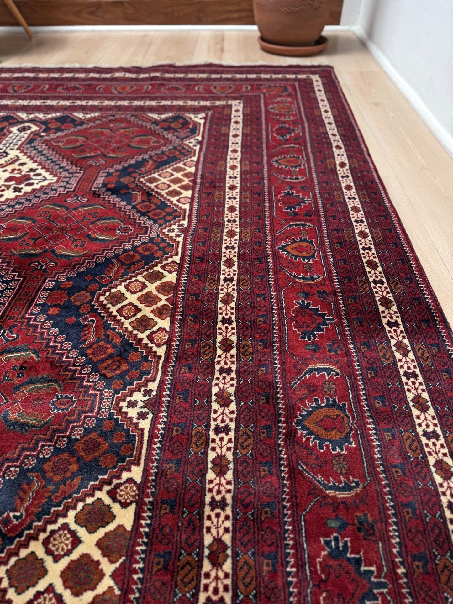 Deep crimson Khal Mohammadi Afghan rug with classic Turkmen gul medallions, dark navy border, ivory details, burgundy, terracotta, beige and forest green accents, handmade Merino wool 10x14 from Indigo Rugs Burlingame Bay Area.