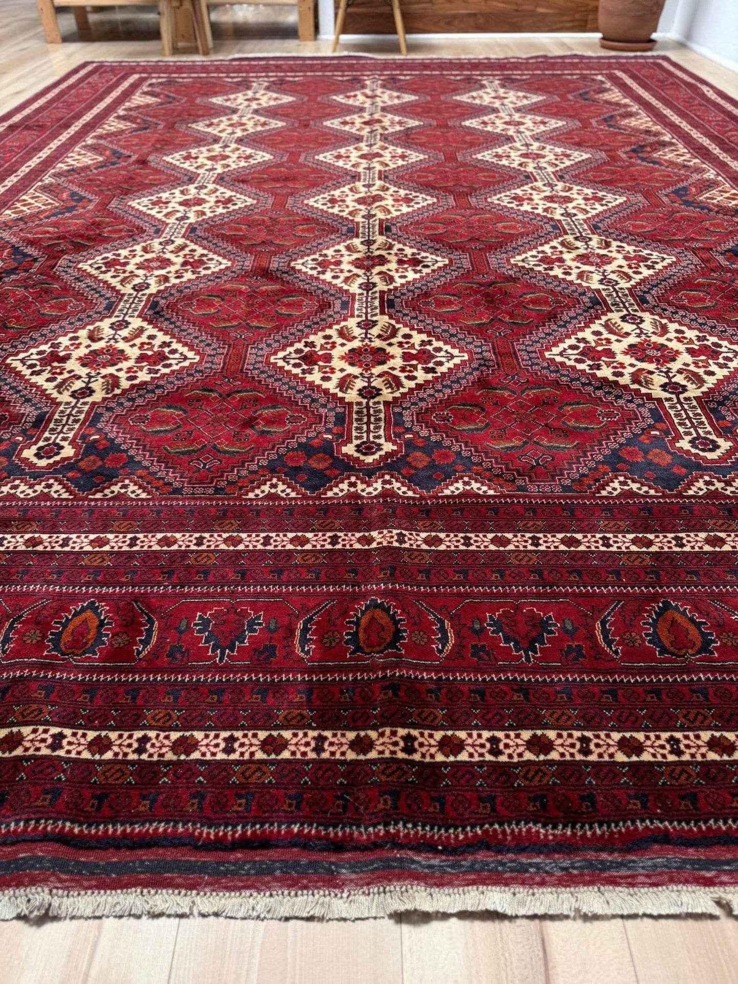Deep crimson Khal Mohammadi Afghan rug with classic Turkmen gul medallions, dark navy border, ivory details, burgundy, terracotta, beige and forest green accents, handmade Merino wool 10x14 from Indigo Rugs Burlingame Bay Area.