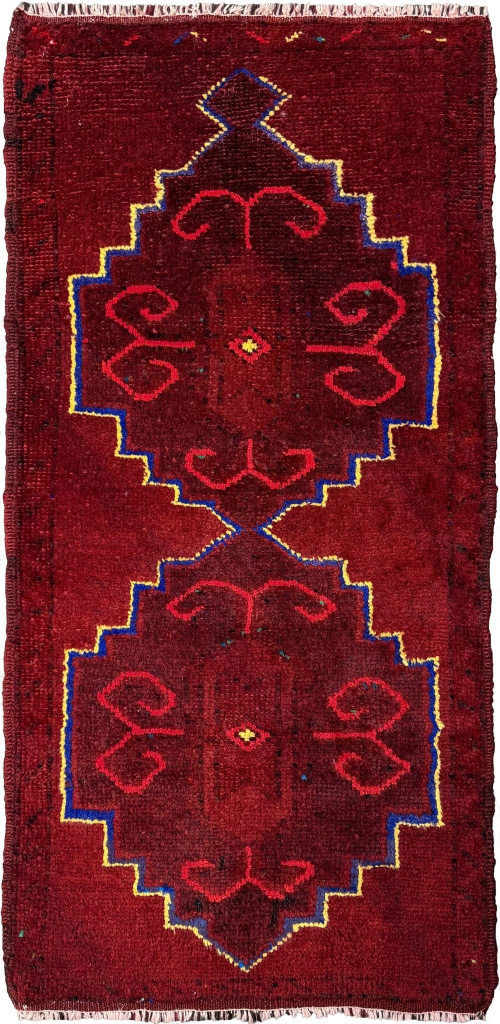 Vintage Turkish Yastik rug in deep cherry red with fuchsia tribal motifs, blue outlines, and yellow highlights. Hand-knotted wool, 20x43 inches. One-of-a-kind piece from Indigo Rugs, the best rug shop in the San Francisco Bay Area (Burlingame, CA). Free shipping included.
