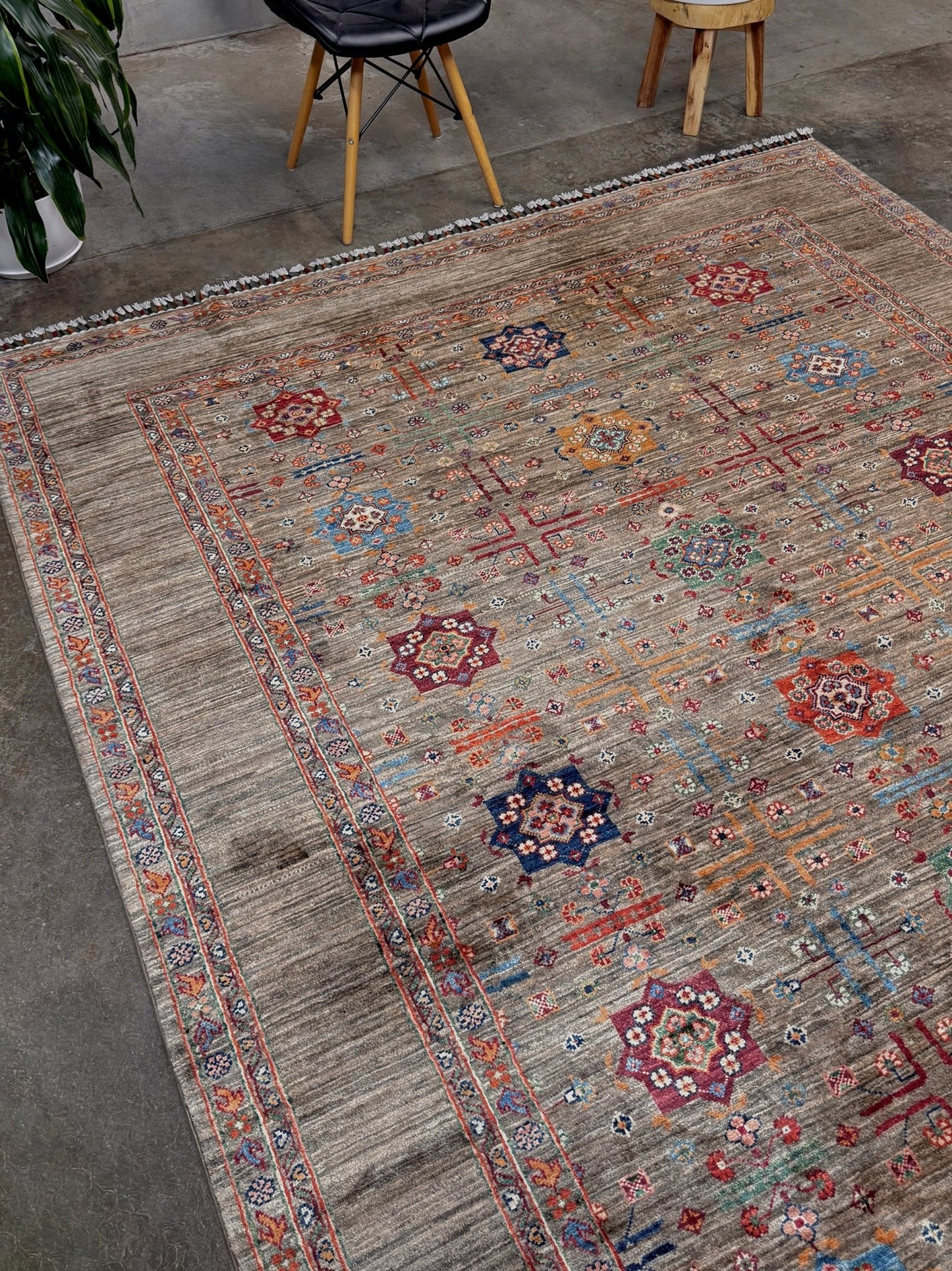 Contemporary Bilcik Turkmen 7x10 rug with dusted olive taupe field, colorful tribal motifs, decorative tassels, handmade Ghazni wool area rug from Indigo Rugs Burlingame Bay Area.