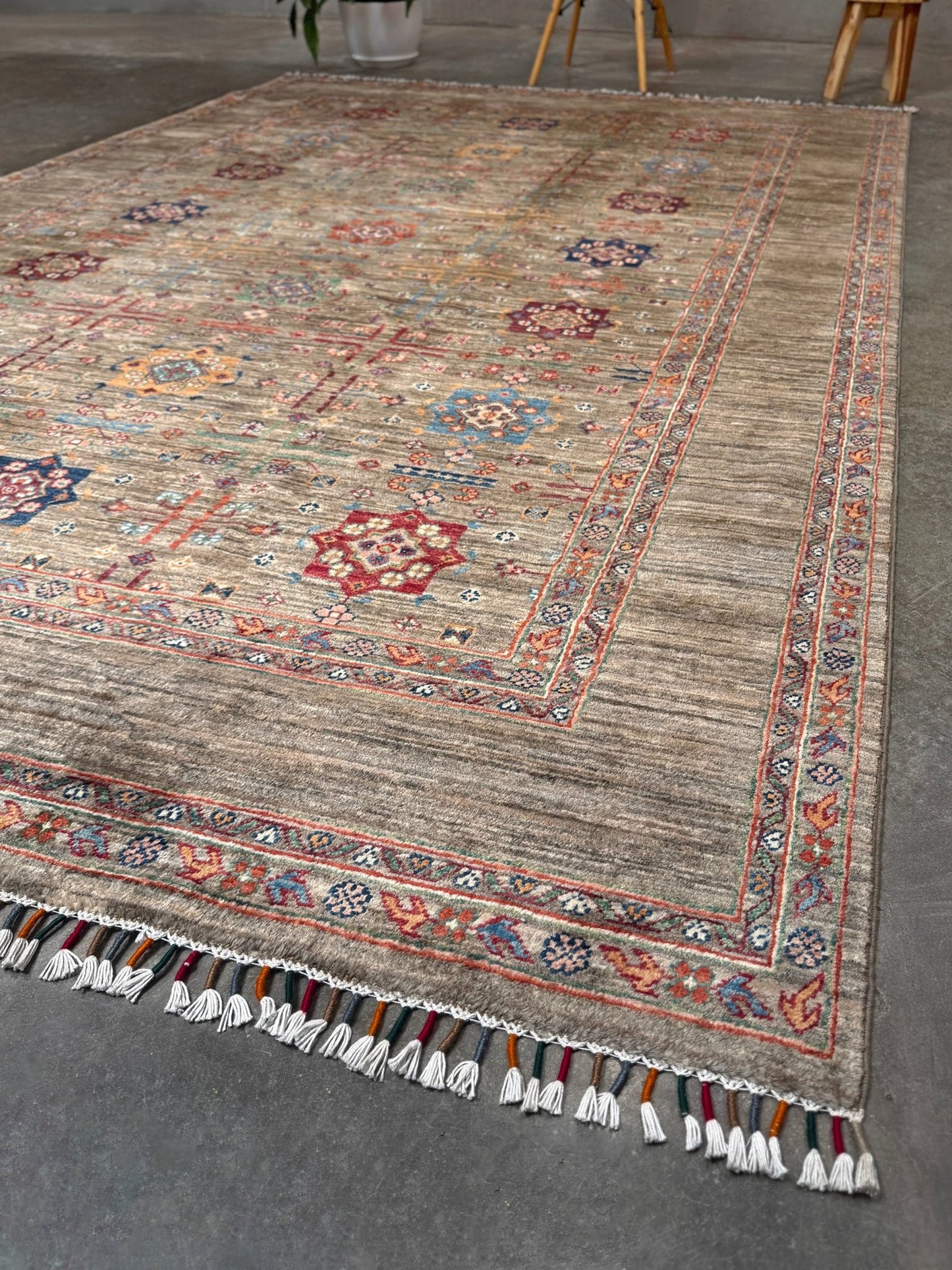 Contemporary Bilcik Turkmen 7x10 rug with dusted olive taupe field, colorful tribal motifs, decorative tassels, handmade Ghazni wool area rug from Indigo Rugs Burlingame Bay Area.