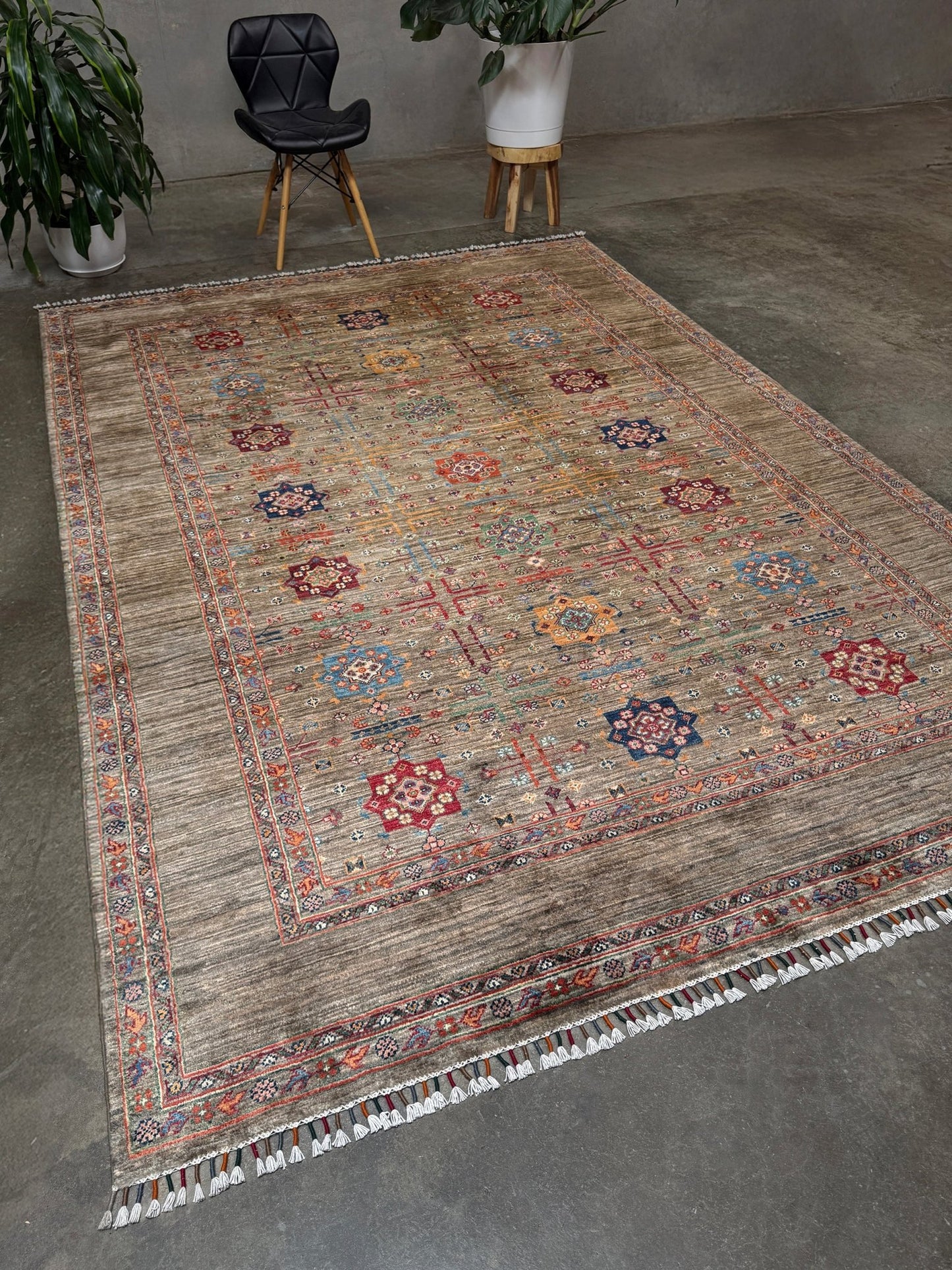Contemporary Bilcik Turkmen 7x10 rug with dusted olive taupe field, colorful tribal motifs, decorative tassels, handmade Ghazni wool area rug from Indigo Rugs Burlingame Bay Area.