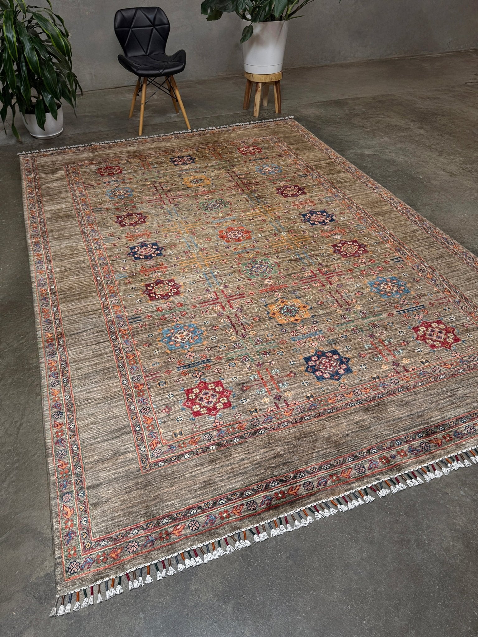 Contemporary Bilcik Turkmen 7x10 rug with dusted olive taupe field, colorful tribal motifs, decorative tassels, handmade Ghazni wool area rug from Indigo Rugs Burlingame Bay Area.