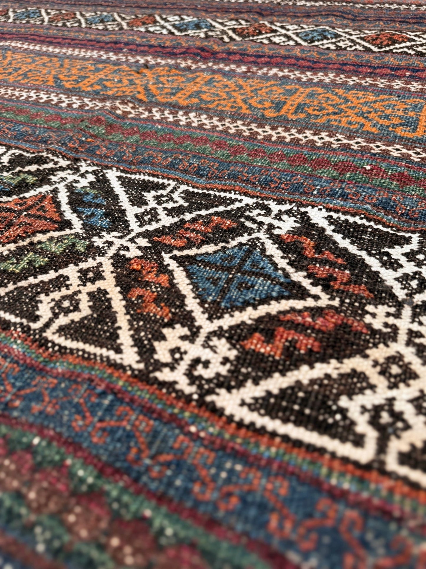 Vintage Persian tribal kilim rug with geometric horizontal bands, brick red, indigo blue, orange, decorative side tassels, handmade wool flatweave 5x6 from Indigo Rugs Burlingame Bay Area.