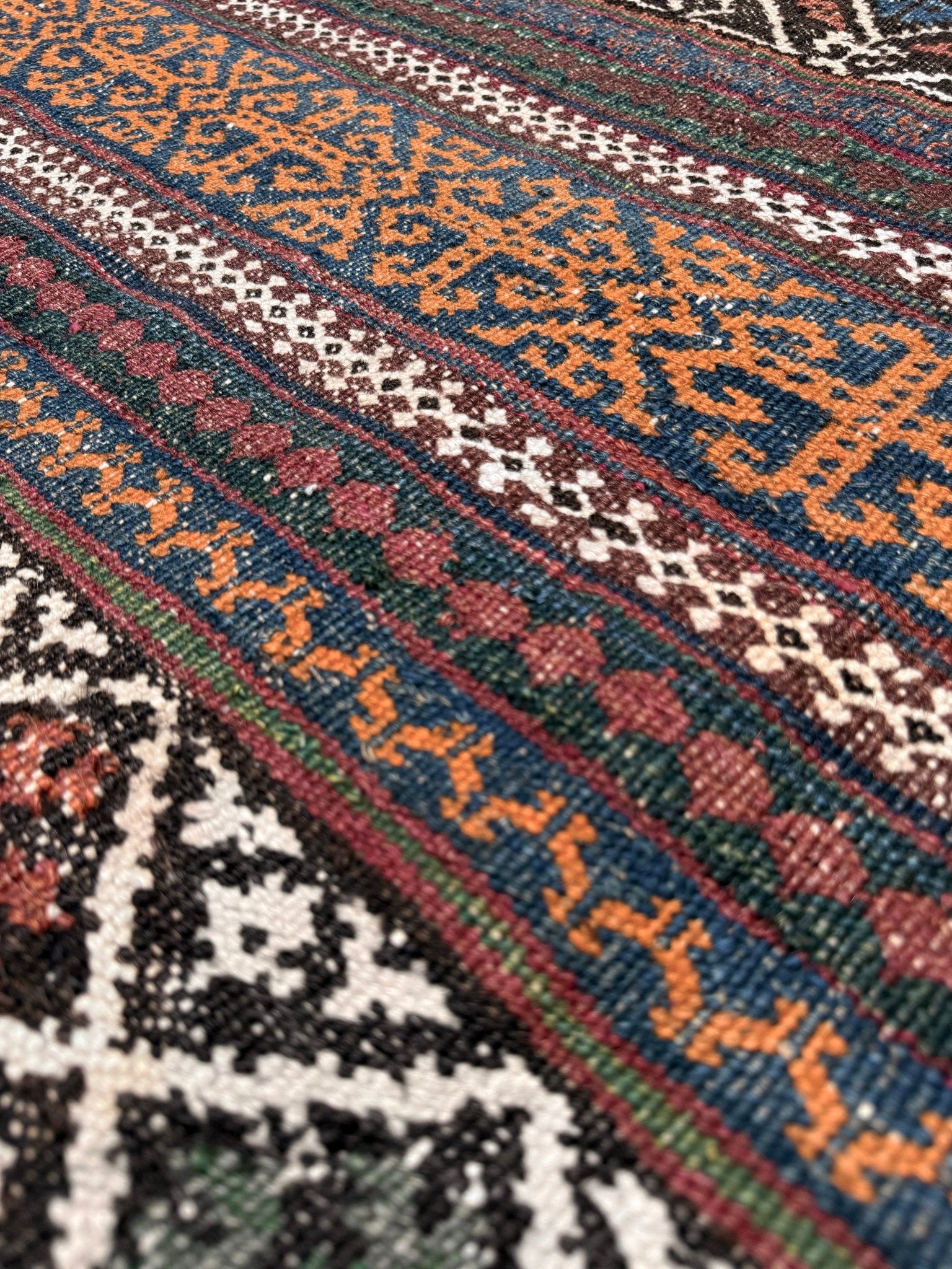 Vintage Persian tribal kilim rug with geometric horizontal bands, brick red, indigo blue, orange, decorative side tassels, handmade wool flatweave 5x6 from Indigo Rugs Burlingame Bay Area.