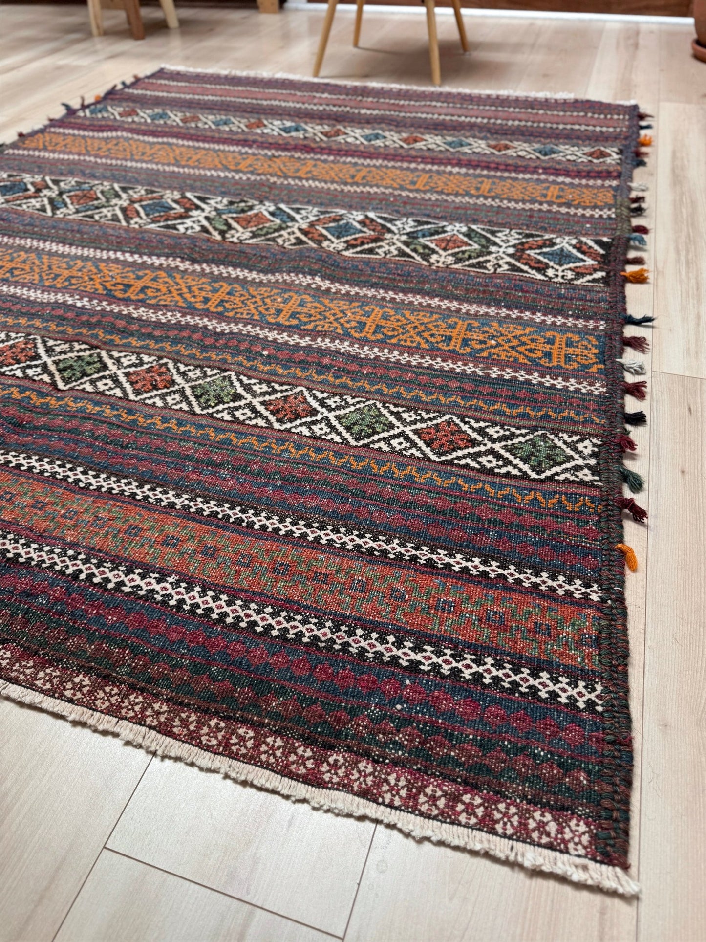 Vintage Persian tribal kilim rug with geometric horizontal bands, brick red, indigo blue, orange, decorative side tassels, handmade wool flatweave 5x6 from Indigo Rugs Burlingame Bay Area.