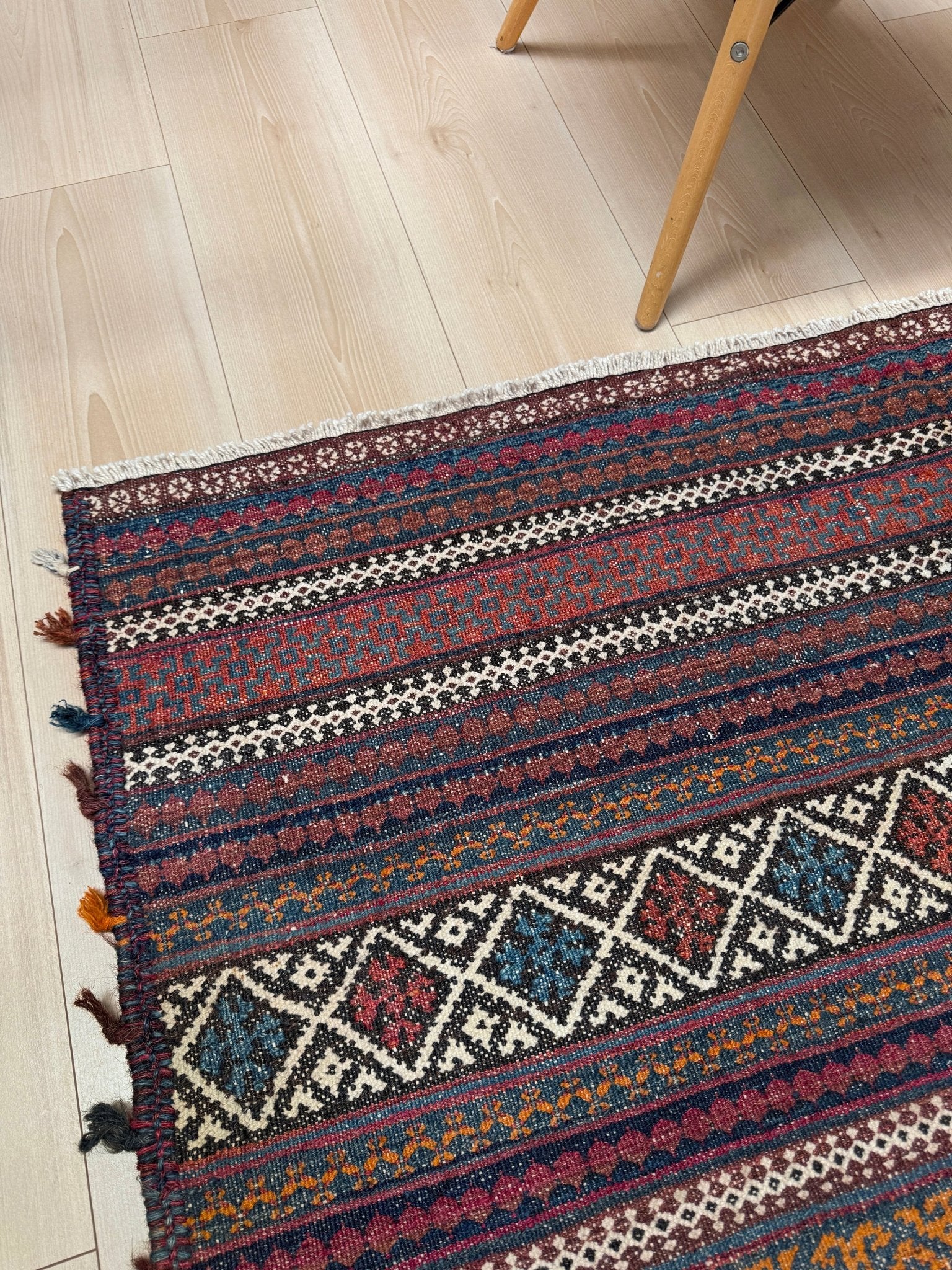 Vintage Persian tribal kilim rug with geometric horizontal bands, brick red, indigo blue, orange, decorative side tassels, handmade wool flatweave 5x6 from Indigo Rugs Burlingame Bay Area.
