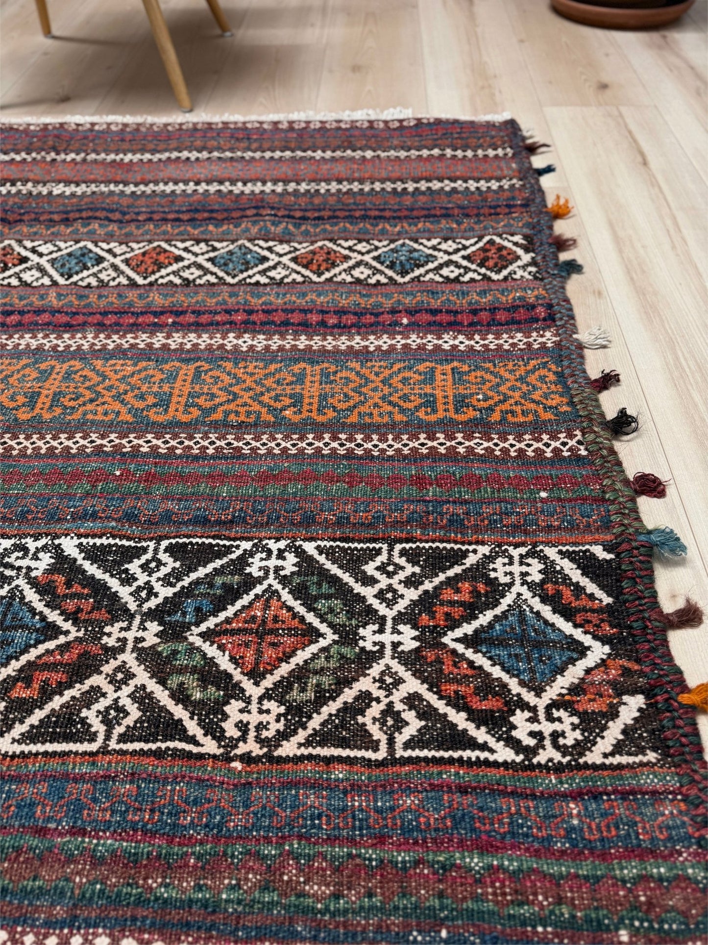 Vintage Persian tribal kilim rug with geometric horizontal bands, brick red, indigo blue, orange, decorative side tassels, handmade wool flatweave 5x6 from Indigo Rugs Burlingame Bay Area.