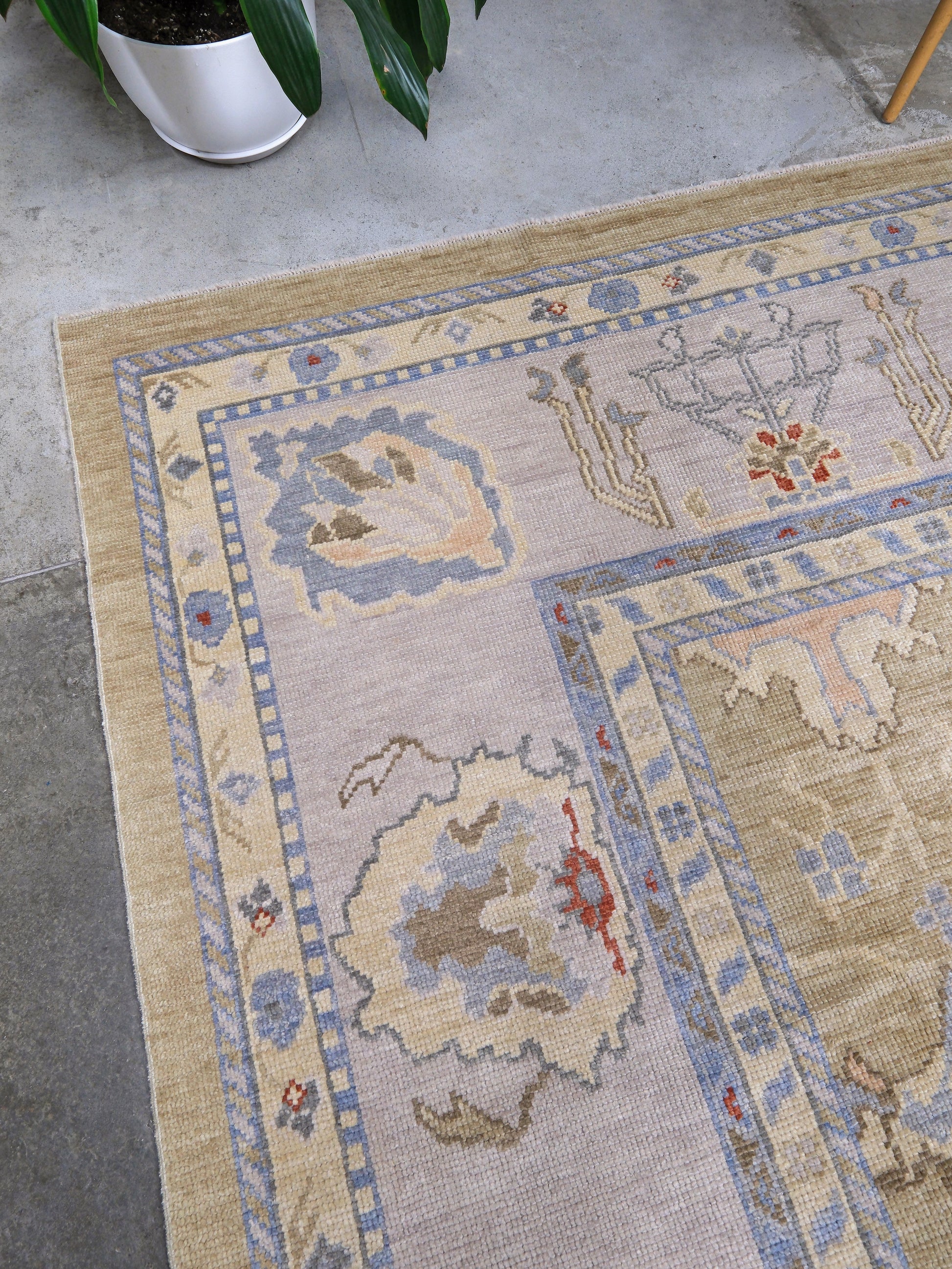 Light olive Turkish Oushak rug with warm ivory border, powder blue floral motifs, soft gray, taupe, and rust accents, hand-knotted wool 10x14 area rug from Indigo Rugs Burlingame Bay Area.