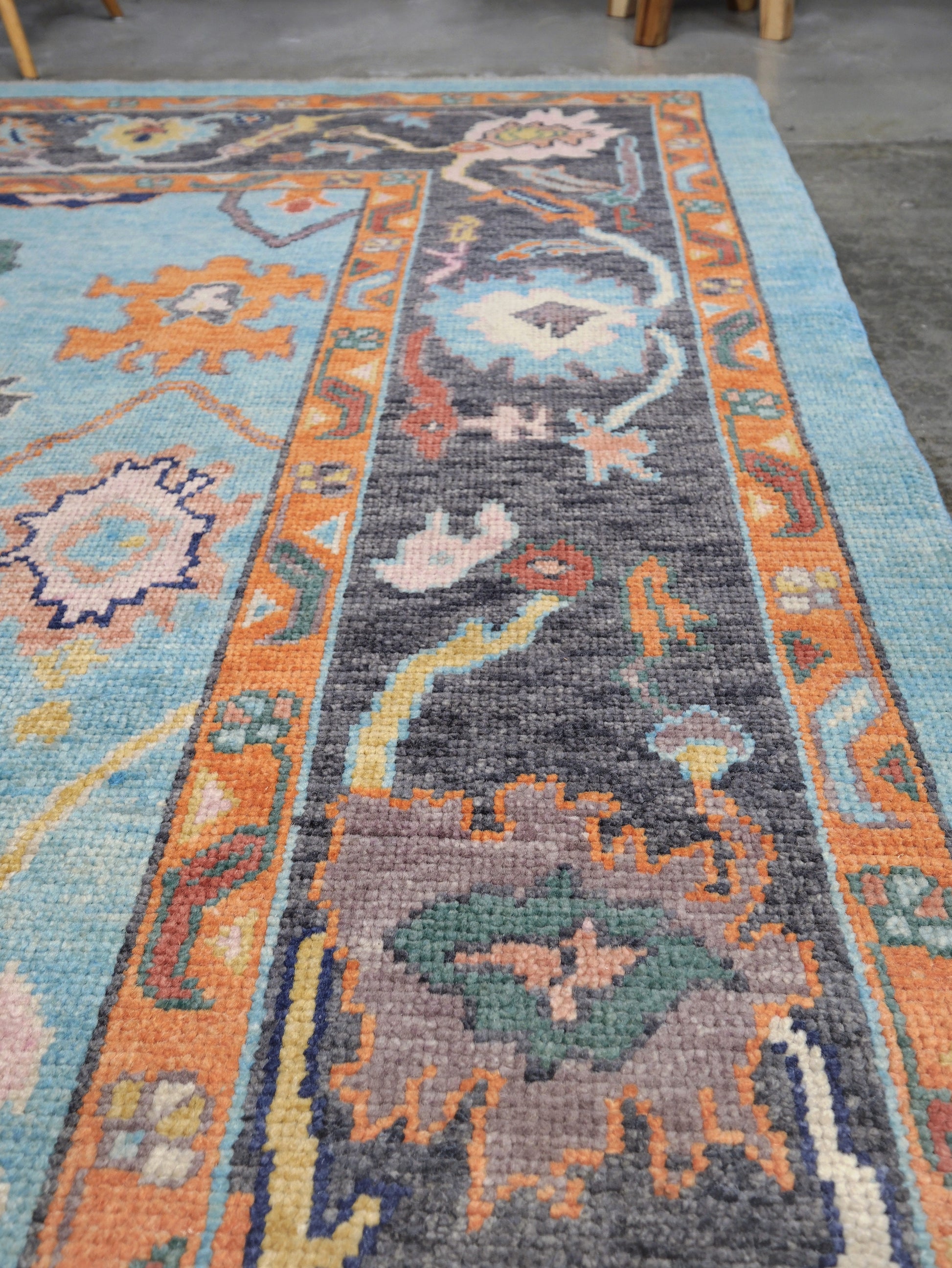 Pale turquoise Turkish Oushak rug with charcoal border, coral orange framing, and colorful abstract floral motifs, hand-knotted wool 8x10 area rug from Indigo Rugs Burlingame Bay Area.