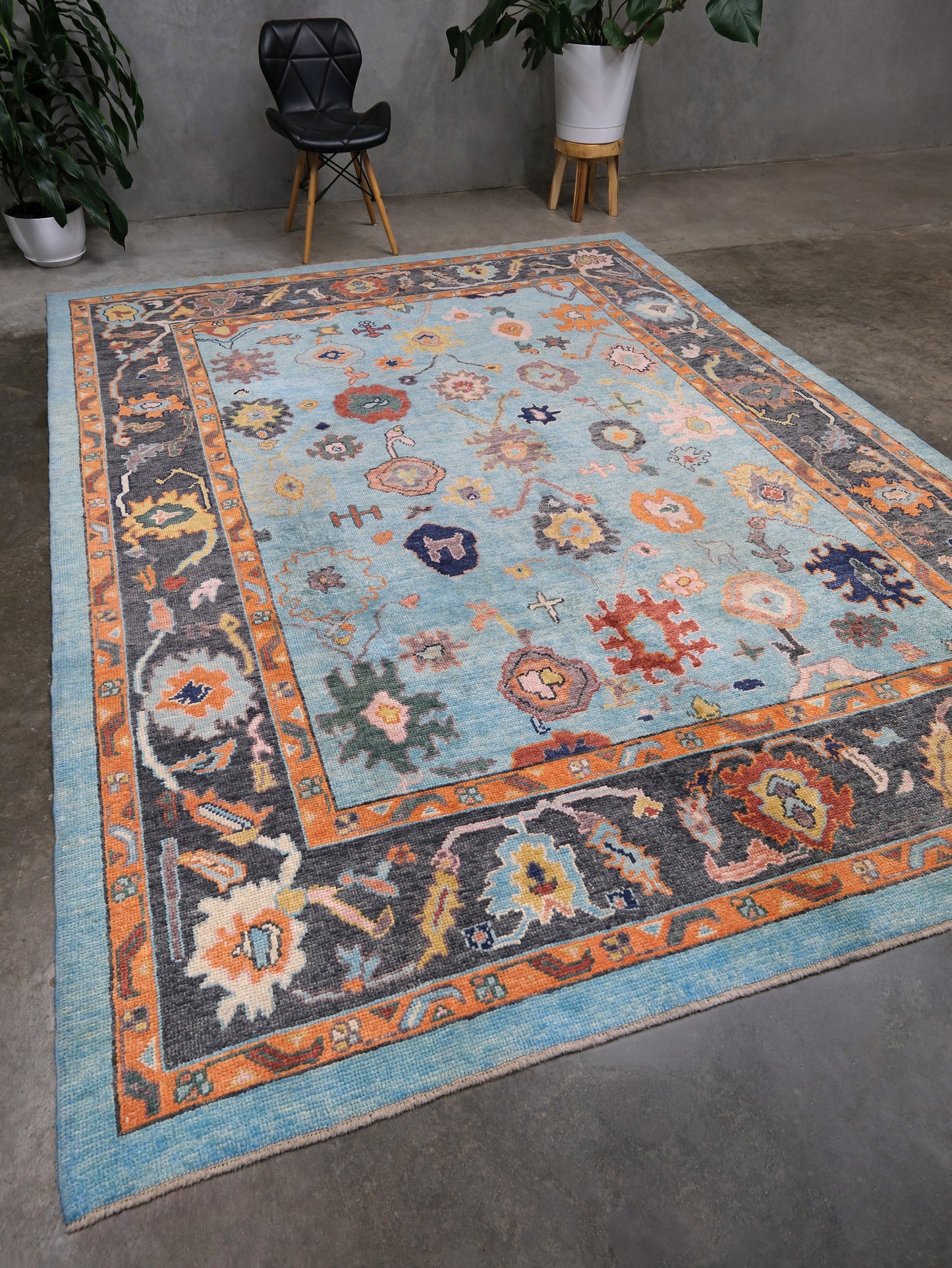 Pale turquoise Turkish Oushak rug with charcoal border, coral orange framing, and colorful abstract floral motifs, hand-knotted wool 8x10 area rug from Indigo Rugs Burlingame Bay Area.