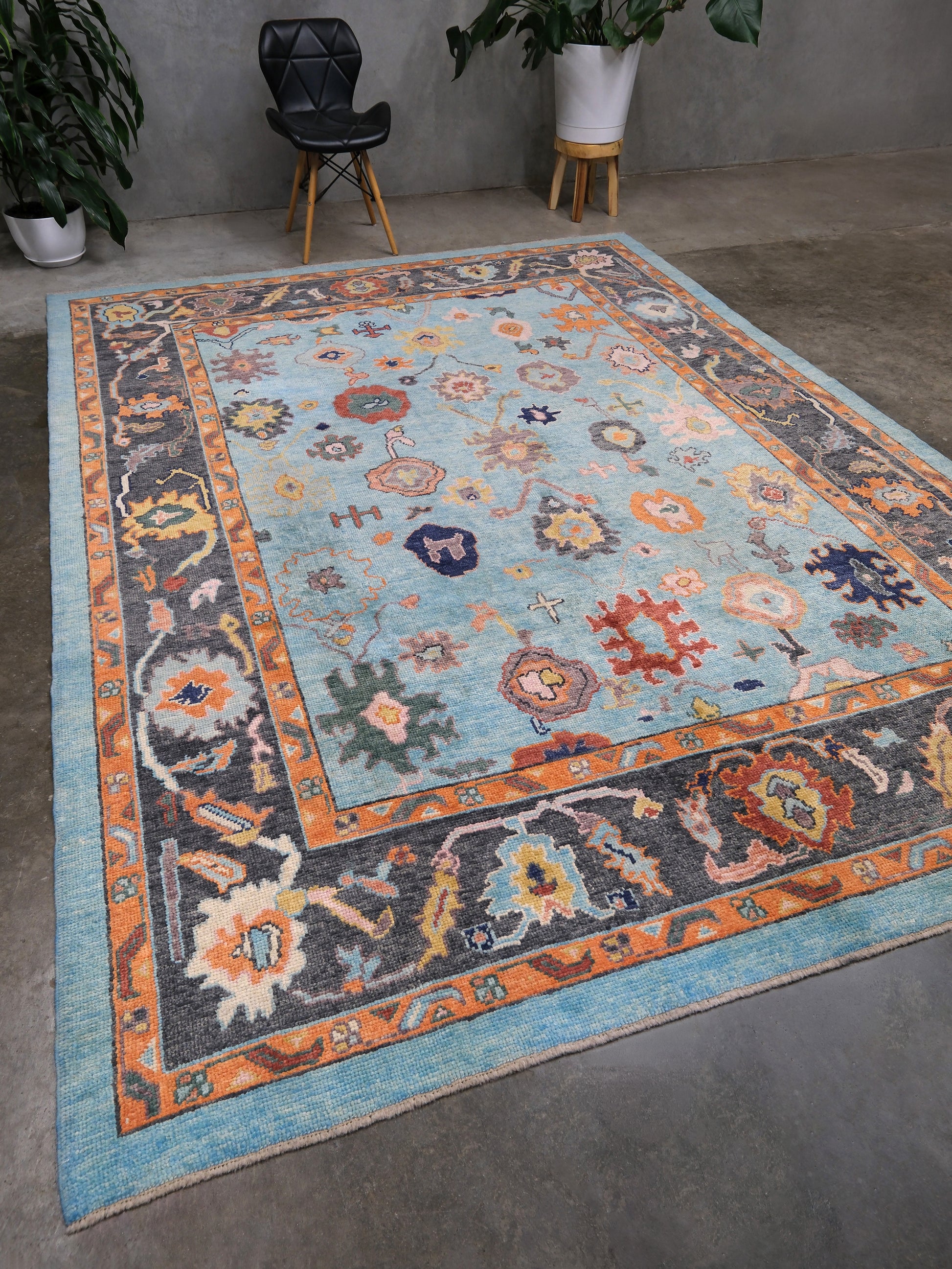 Pale turquoise Turkish Oushak rug with charcoal border, coral orange framing, and colorful abstract floral motifs, hand-knotted wool 8x10 area rug from Indigo Rugs Burlingame Bay Area.
