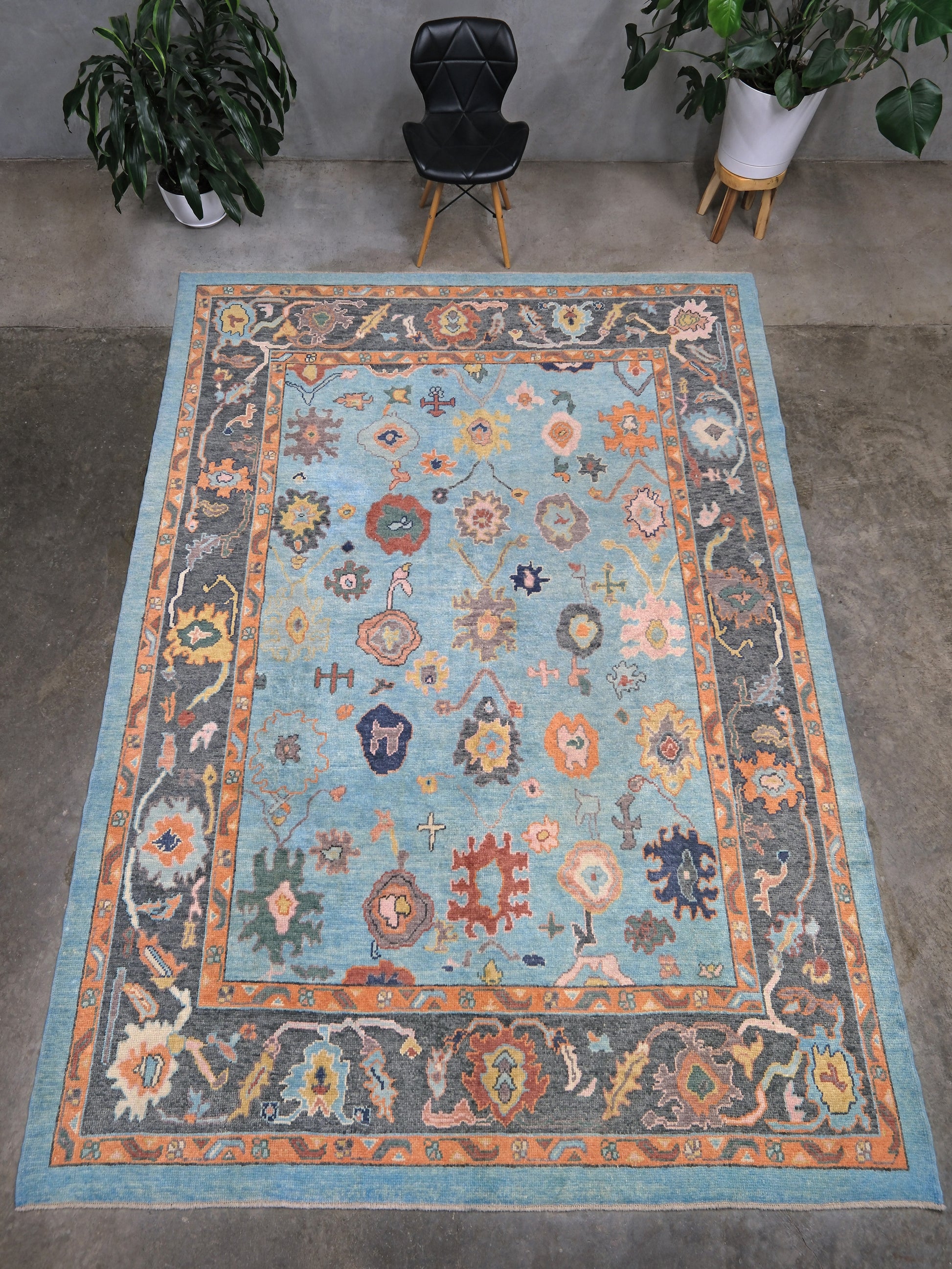 Pale turquoise Turkish Oushak rug with charcoal border, coral orange framing, and colorful abstract floral motifs, hand-knotted wool 8x10 area rug from Indigo Rugs Burlingame Bay Area.