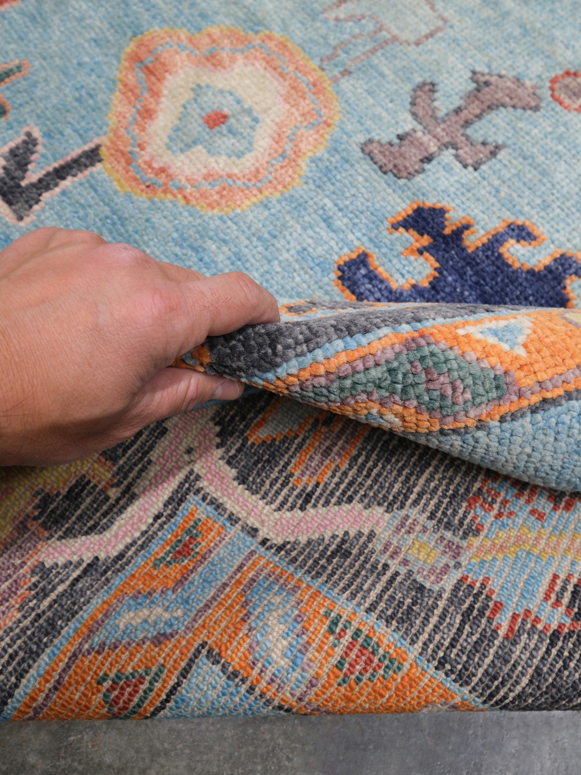 Pale turquoise Turkish Oushak rug with charcoal border, coral orange framing, and colorful abstract floral motifs, hand-knotted wool 8x10 area rug from Indigo Rugs Burlingame Bay Area.