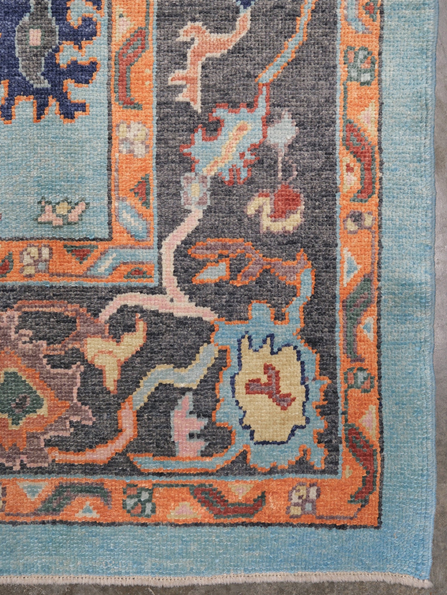 Pale turquoise Turkish Oushak rug with charcoal border, coral orange framing, and colorful abstract floral motifs, hand-knotted wool 8x10 area rug from Indigo Rugs Burlingame Bay Area.