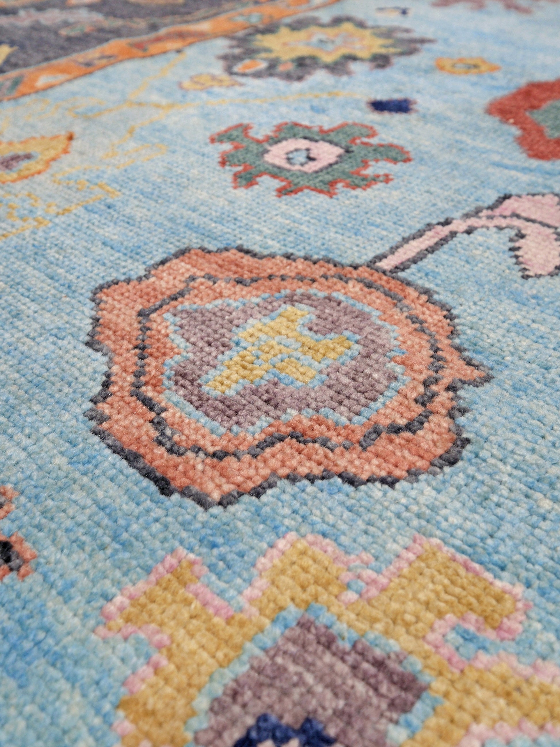 Pale turquoise Turkish Oushak rug with charcoal border, coral orange framing, and colorful abstract floral motifs, hand-knotted wool 8x10 area rug from Indigo Rugs Burlingame Bay Area.