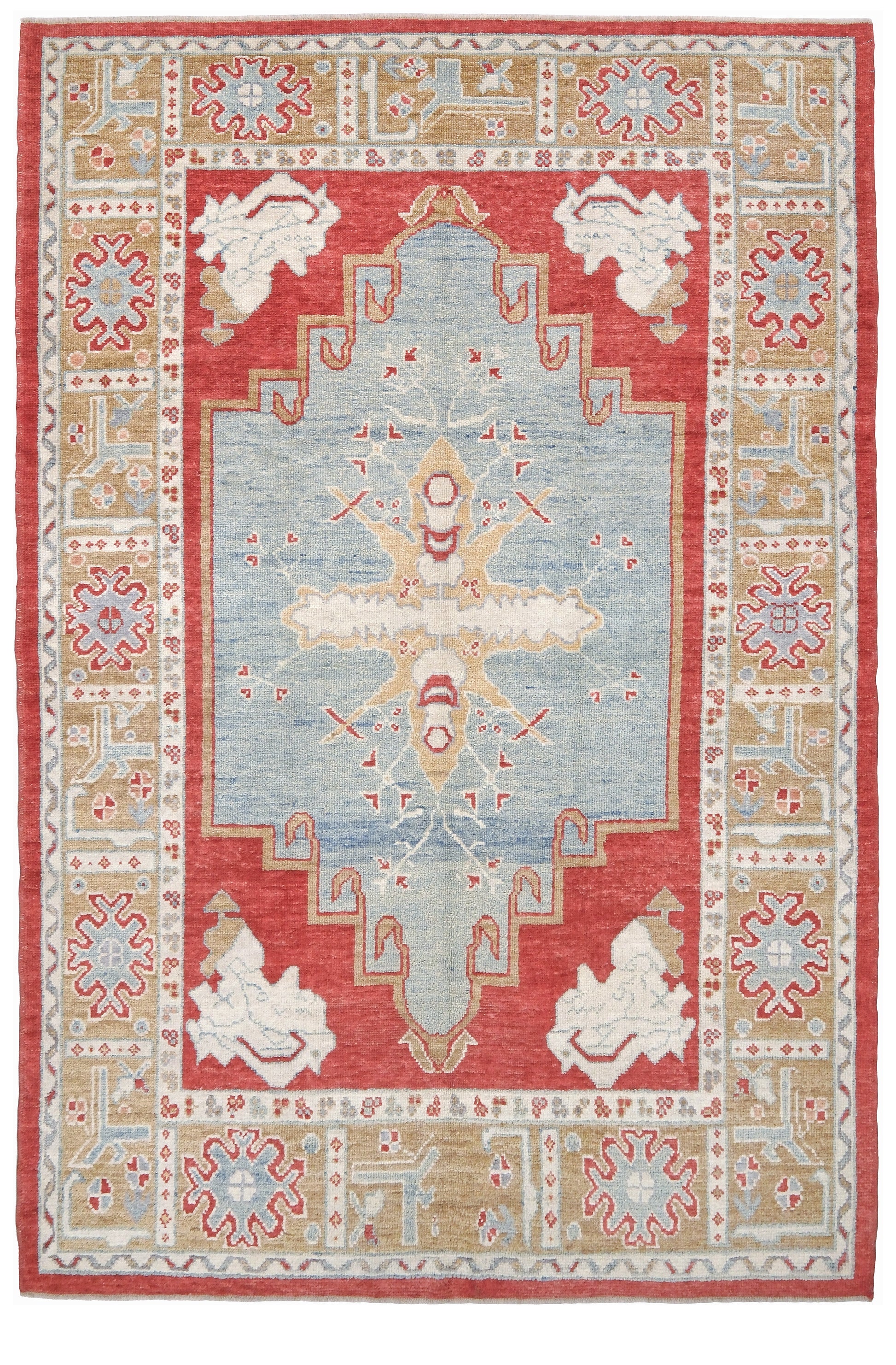 A rectangular area rug with a traditional geometric pattern, featuring a central light blue medallion, a red field, and beige and white border motifs. Vibrant soft sky blue and coral 7x10 Turkish Oushak rug with central medallion, golden beige border, floral motifs and warm ivory accents, handmade wool from Indigo Rugs Burlingame Bay Area.