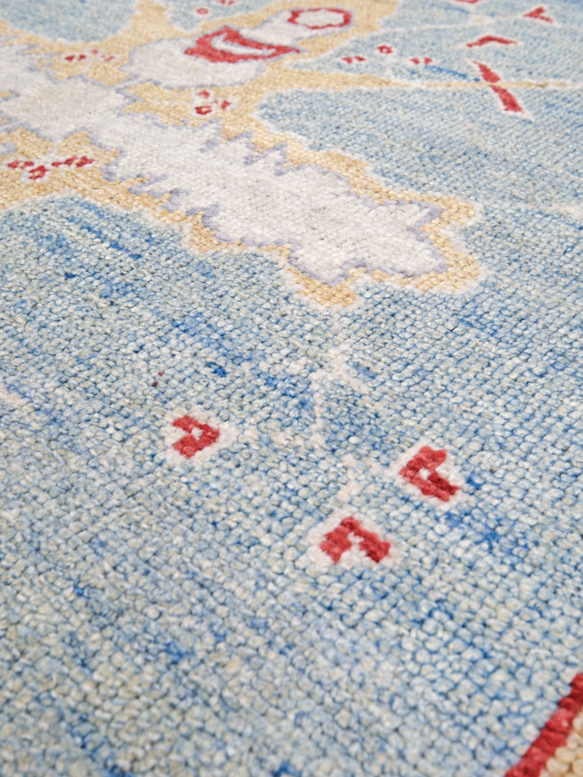 Vibrant soft sky blue and coral 7x10 Turkish Oushak rug with central medallion, golden beige border, floral motifs and warm ivory accents, handmade wool from Indigo Rugs Burlingame Bay Area.