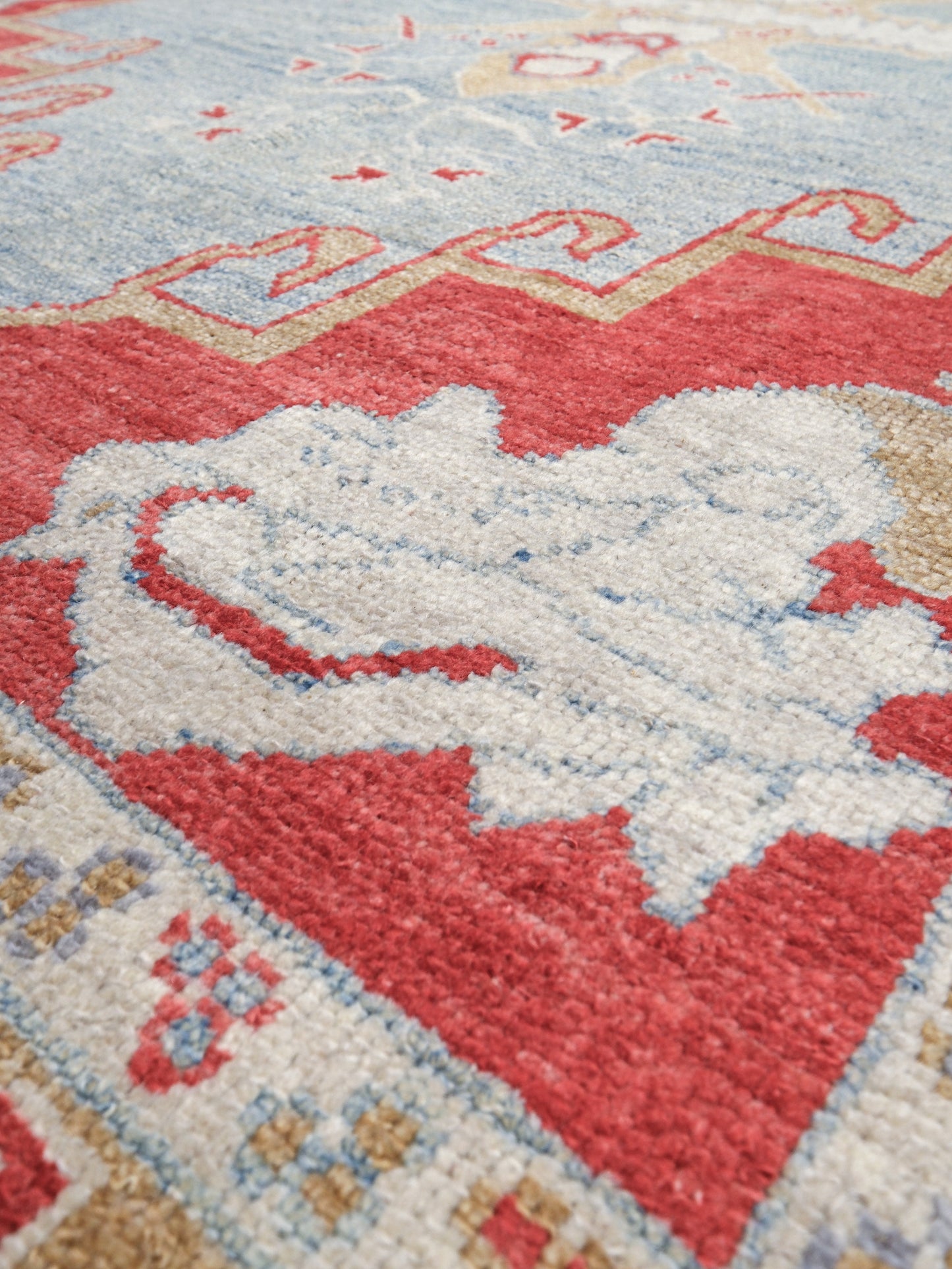 Vibrant soft sky blue and coral red 7x10 Turkish Oushak rug with central medallion, golden beige border, floral motifs and warm ivory accents, handmade wool from Indigo Rugs Burlingame Bay Area.