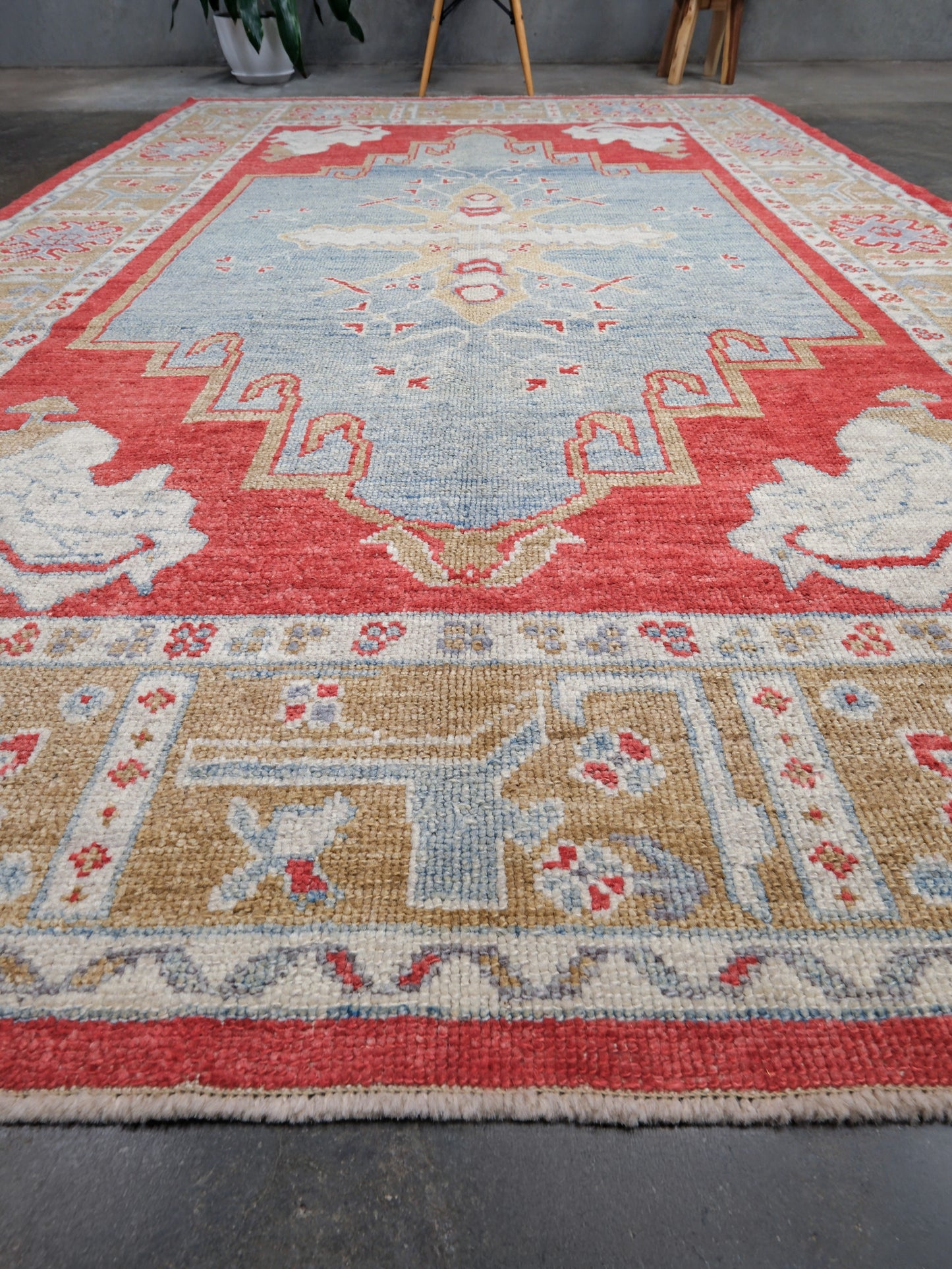 Vibrant soft sky blue and coral 7x10 Turkish Oushak rug with central medallion, golden beige border, floral motifs and warm ivory accents, handmade wool from Indigo Rugs Burlingame Bay Area.