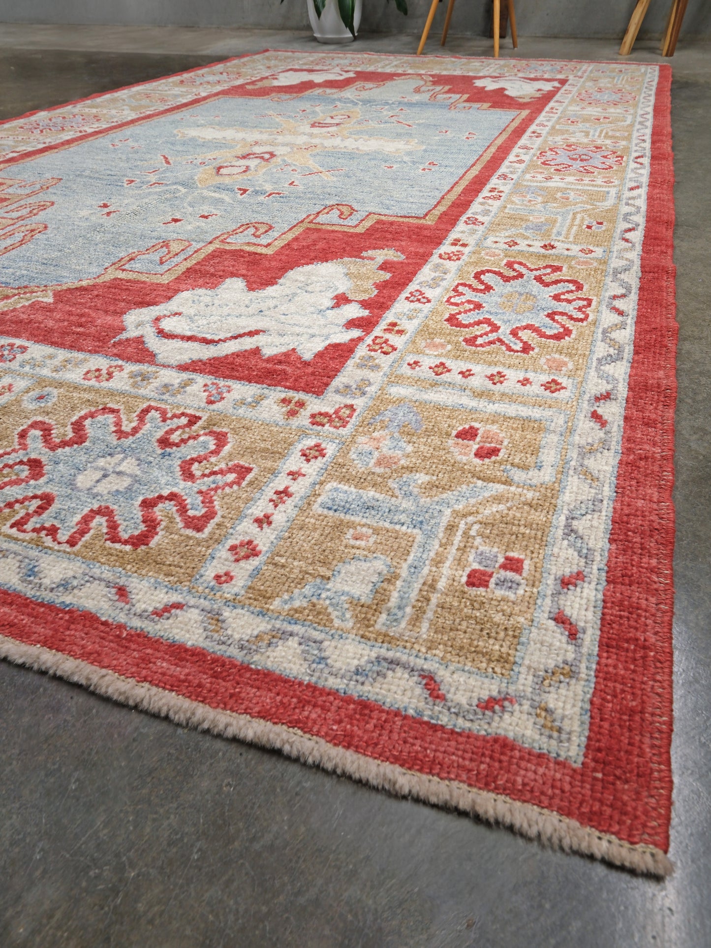 Vibrant soft sky blue and coral 7x10 Turkish Oushak rug with central medallion, golden beige border, floral motifs and warm ivory accents, handmade wool from Indigo Rugs Burlingame Bay Area.