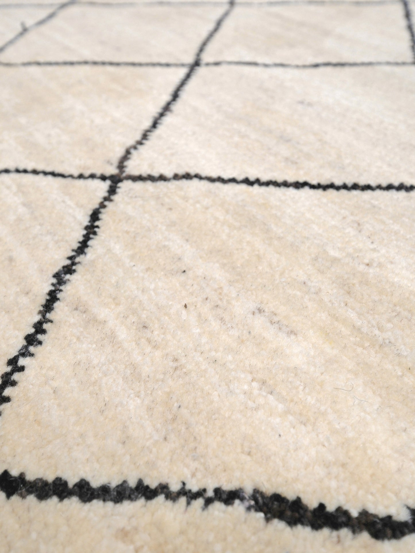 Ivory natural beige minimalist Moroccan handmade wool rug with black diamond pattern, soft cream field and organic modern geometric design, 6x8 from Indigo Rugs Burlingame Bay Area.