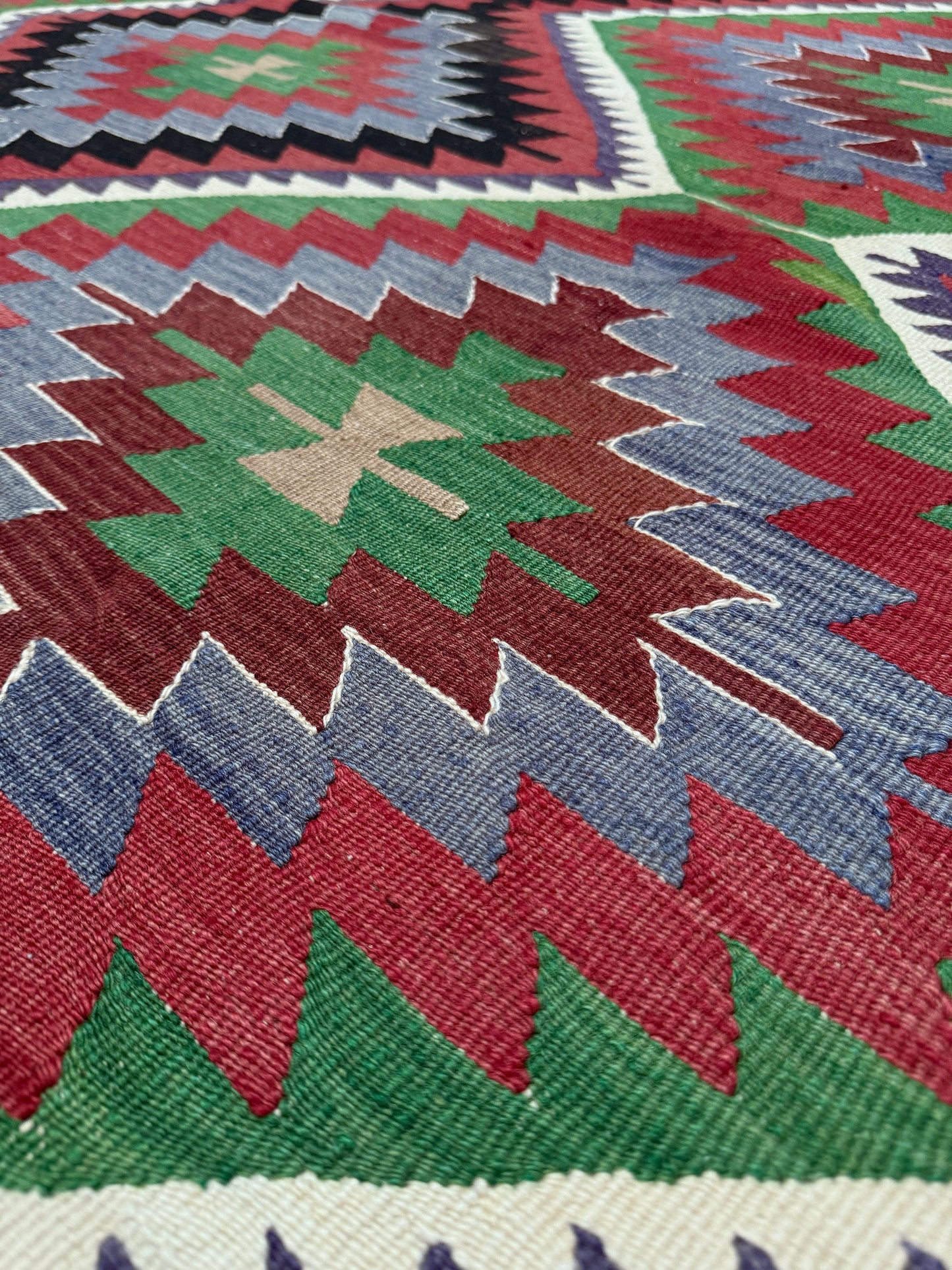 Close-up of a colorful geometric patterned rug with vibrant colors. Vintage Esme Turkish kilim featuring navajo style geometric design, handwoven wool flatweave rug 6x9