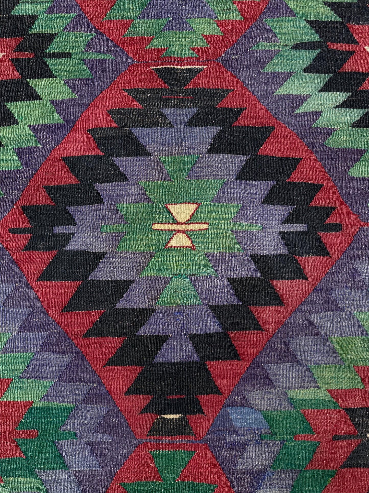 Colorful geometric patterned rug with a diamond shape and central design. Vintage Esme Turkish tribal kilim rug featuring geometric design in raspberry red, blue violet, emerald green, handmade 6x10 perfect for boho style 