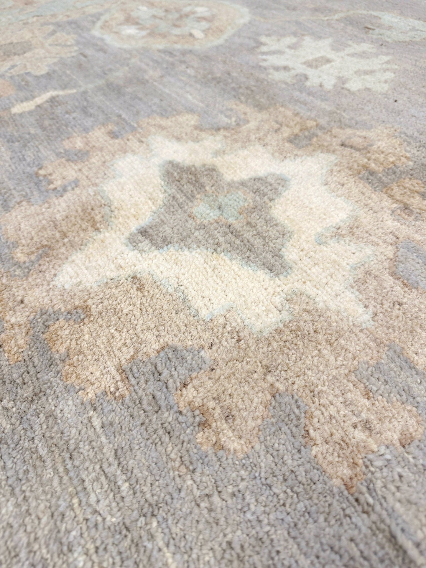 Close-up of 8x10 handmade Turkish Oushak rug in slate gray with aqua and beige accents, transitional design for modern or classic home décor. Perfect for living room, dining room, or bedroom. Indigo Rugs – Burlingame SF Bay Area. Free shipping.