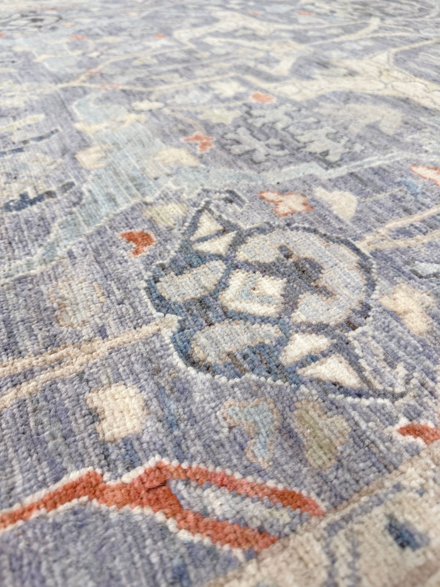 Close-up of Neutral Handmade 6x9 Arabesque Bijar Persian rug in silvery gray with blue undertone, ivory vines, muted blue details, terracotta and rust highlights, and muted midnight blue outlines – transitional Persian wool rug for living room bedroom dining. Free shipping