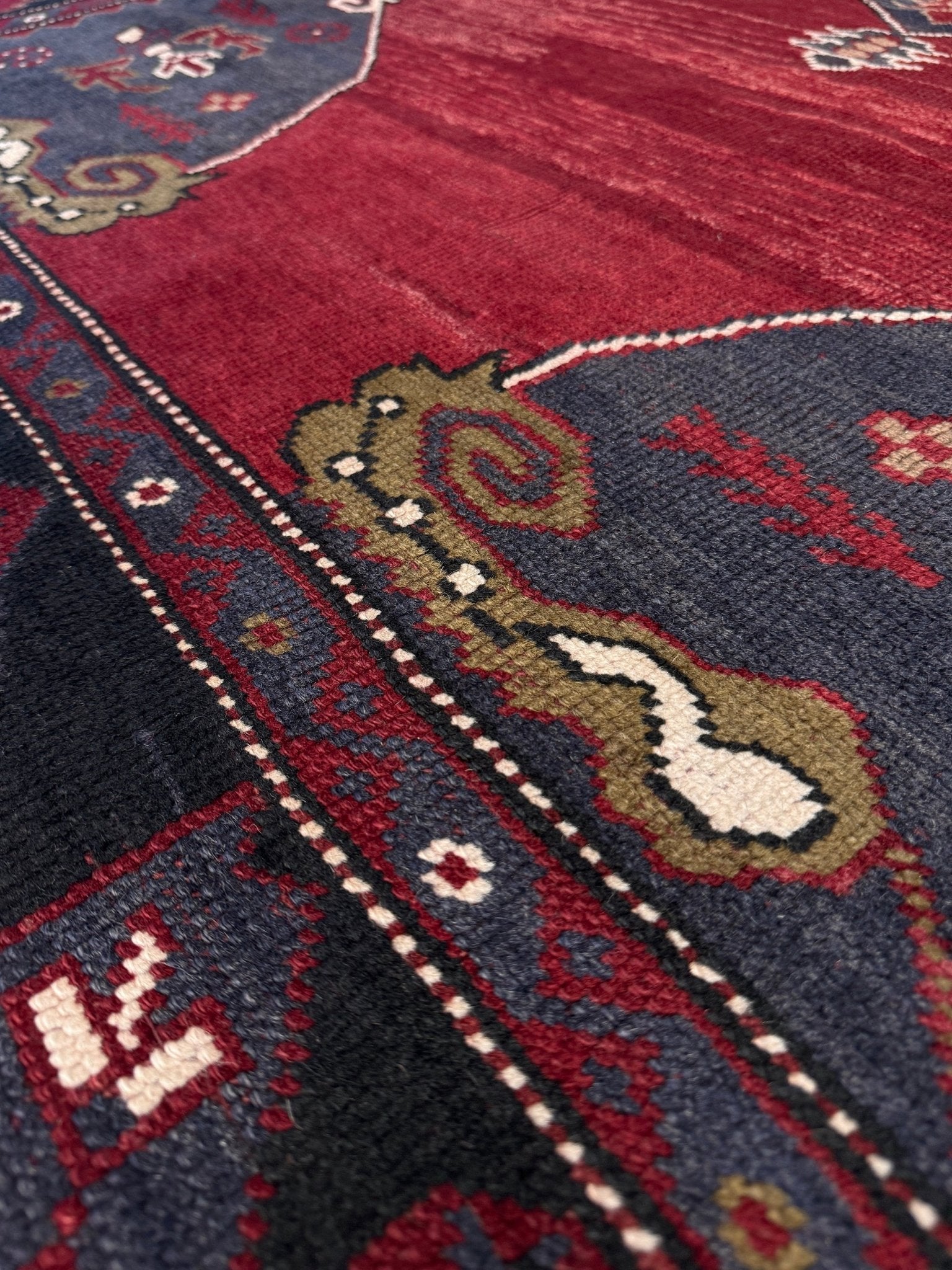 Close-up of a patterned rug with intricate designs. Antique kiz bergama turkish rug 6x8 deep madder red field indigo clue medallion anatolian village rug 1920s indigo rugs san francisco bay area