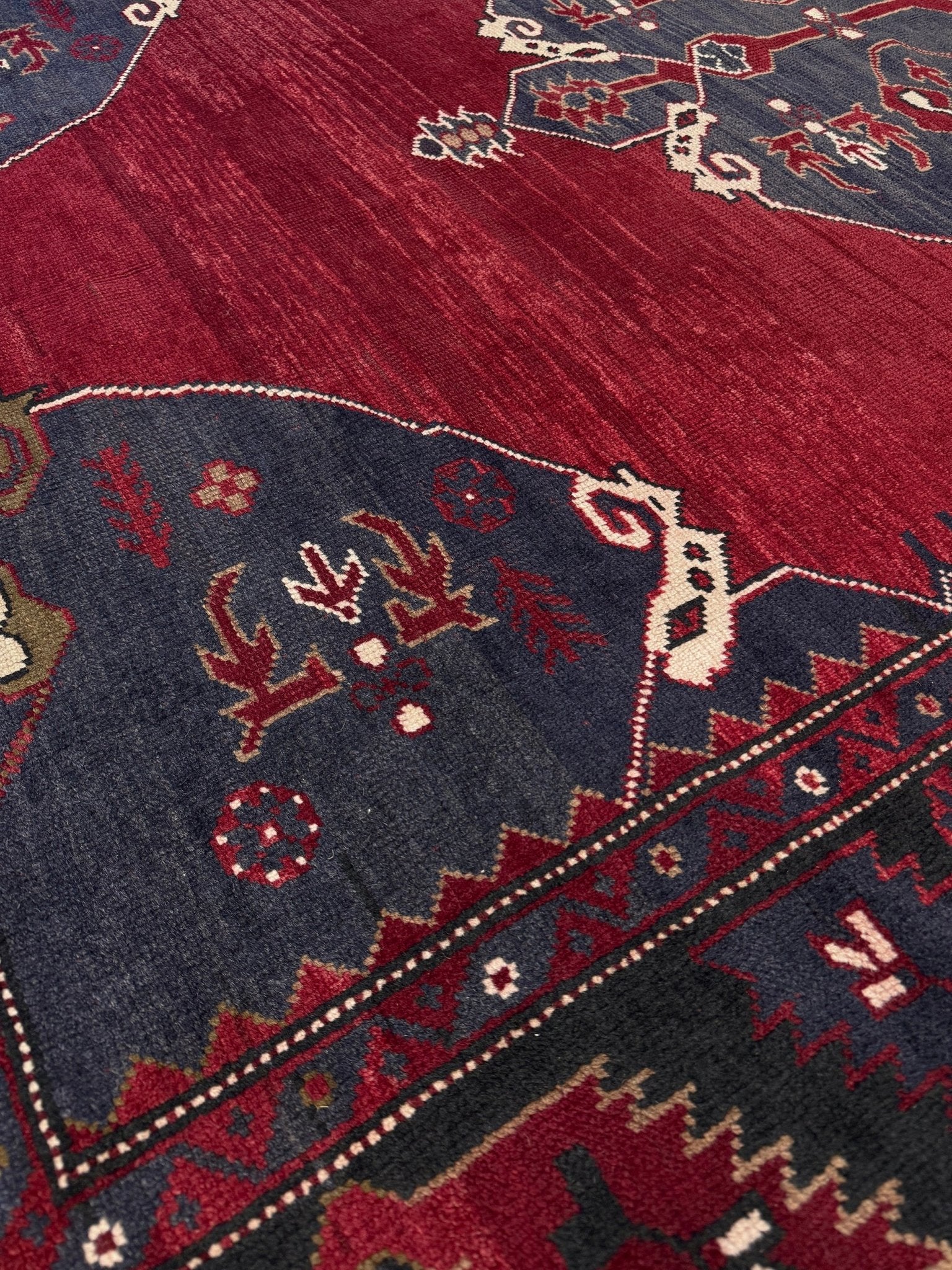 Close-up of a red and blue patterned rug with intricate designs. Antique kiz bergama turkish rug 6x8 deep madder red field indigo clue medallion anatolian village rug 1920s indigo rugs san francisco bay area
