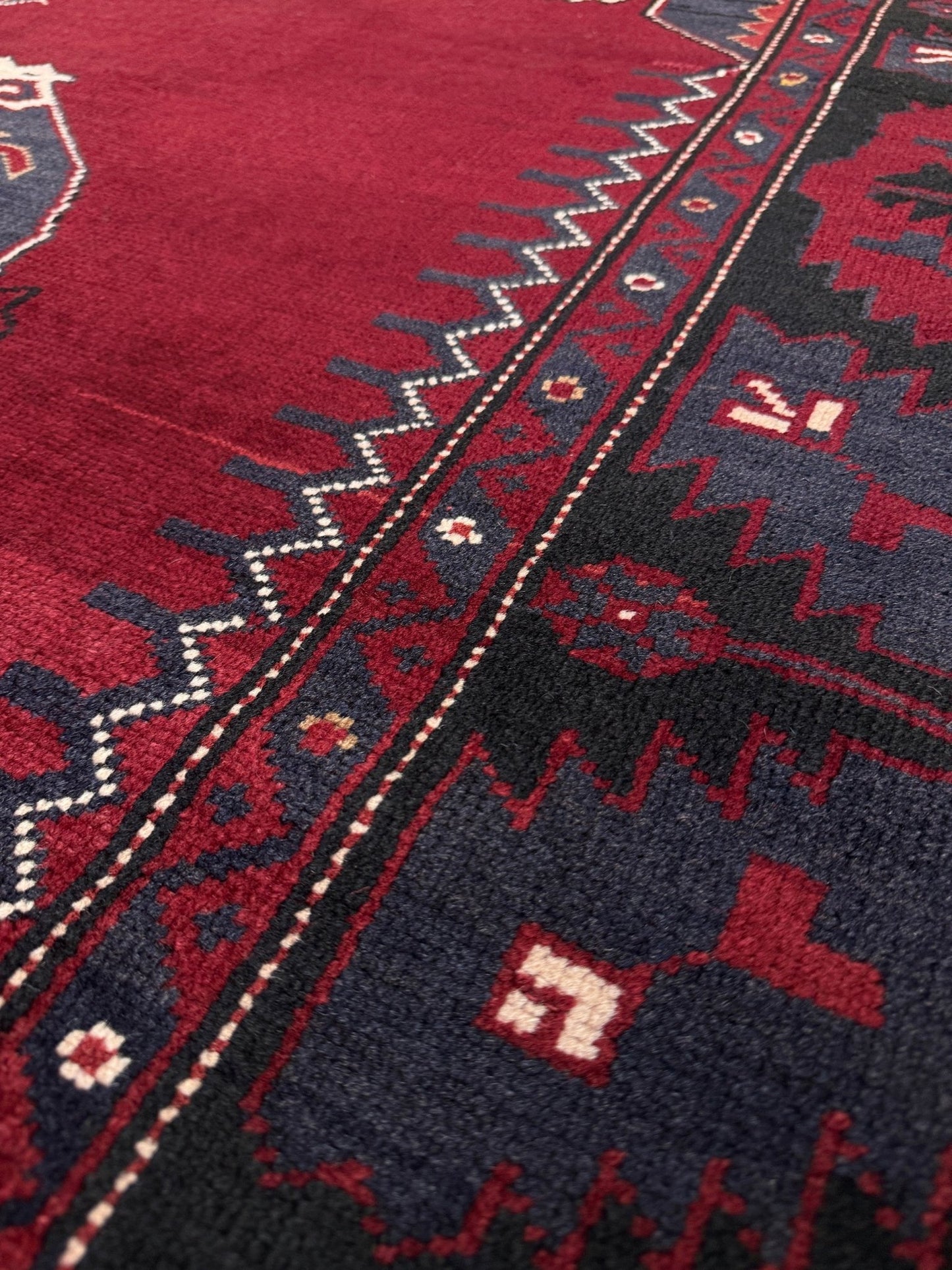 Close-up of a red and black patterned rug. Antique kiz bergama turkish rug 6x8 deep madder red field indigo clue medallion anatolian village rug 1920s indigo rugs san francisco bay area
