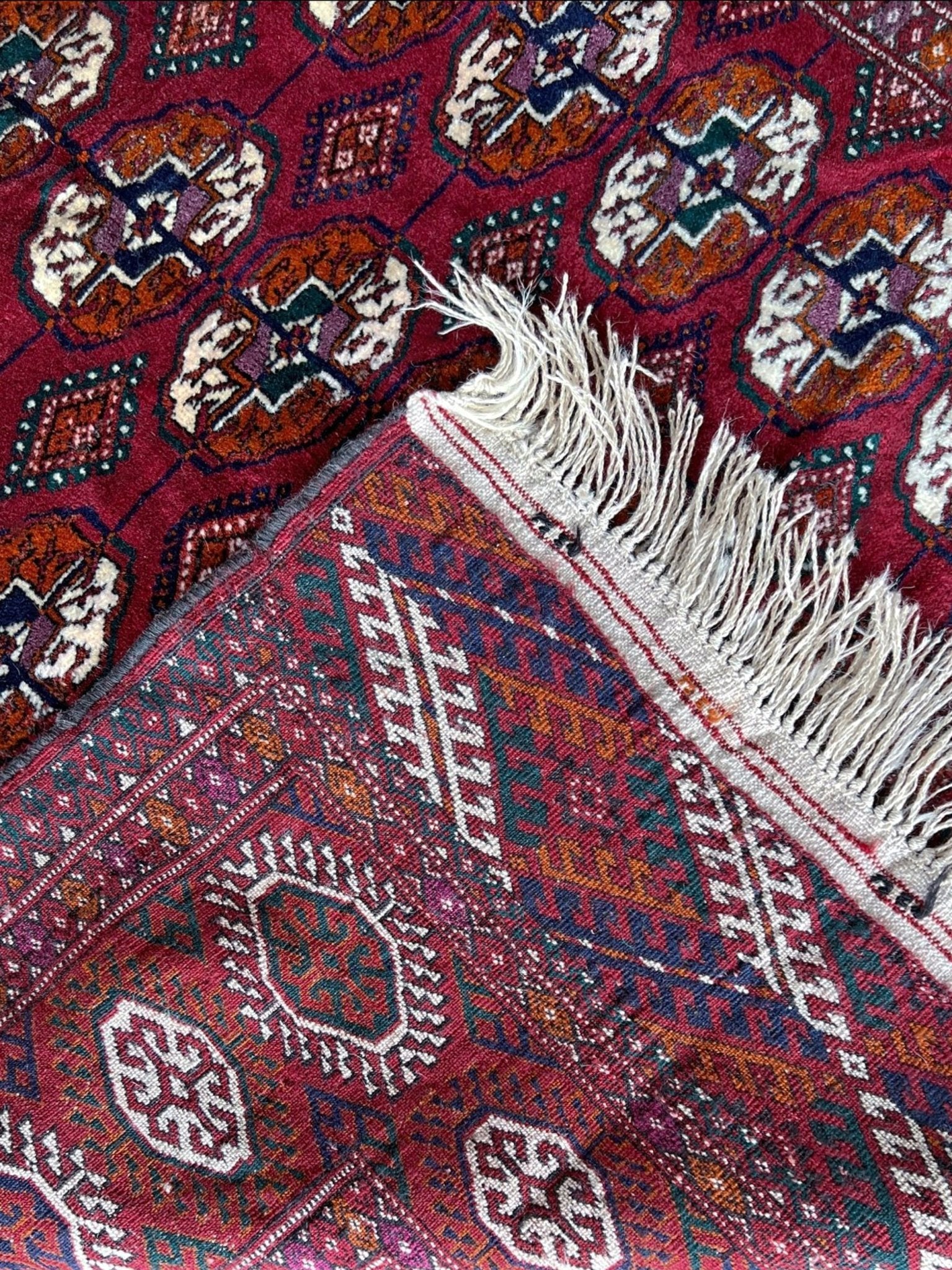 Vintage Turkmen Burgundy Bukhara rug 4x6 with repeating ivory gul motifs, velvety wool pile and classic tribal border. Hand-knotted wool decorative scatter rug for living room bedroom office from Indigo Rugs, Burlingame — the best rug shop in the San Francisco Bay Area. Free shipping.