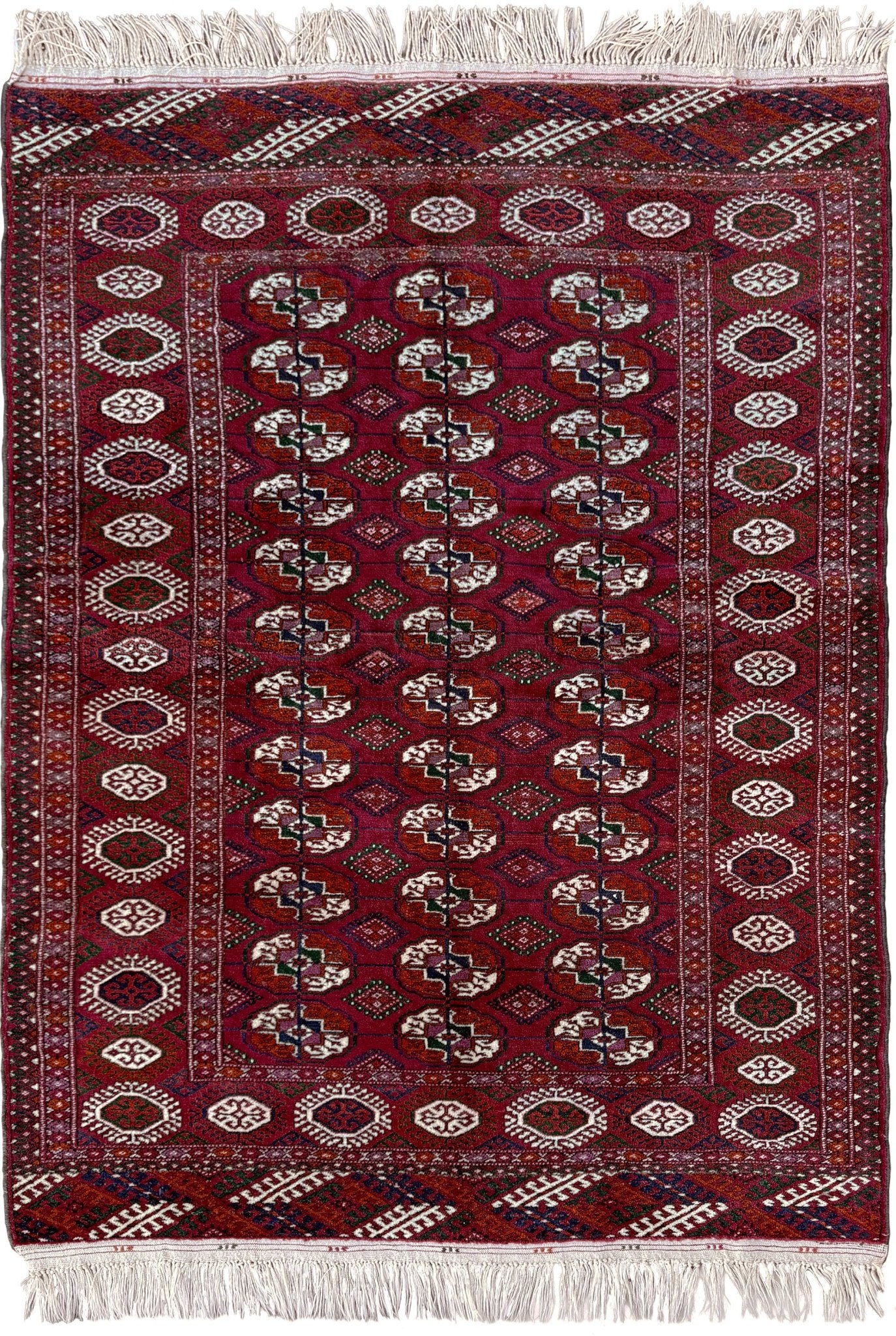 Vintage Turkmen Burgundy Bukhara rug 4x6 with repeating ivory gul motifs, velvety wool pile and classic tribal border. Hand-knotted wool scatter rug for living room bedroom office from Indigo Rugs, Burlingame — the best rug shop in the San Francisco Bay Area. Free shipping.