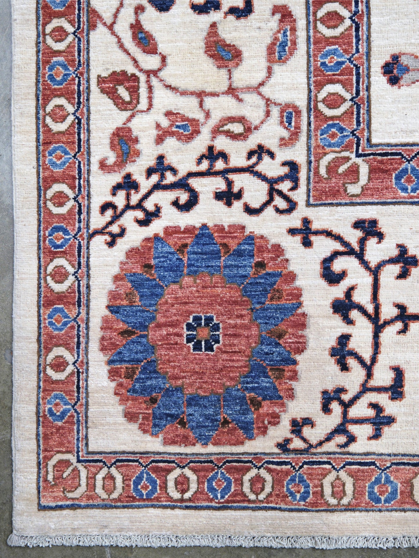 Ivory Suzani style handmade Turkish wool rug with paisley motifs, branching vines, flowers, indigo blue and rust accents, 9x12 from Indigo Rugs Burlingame Bay Area.