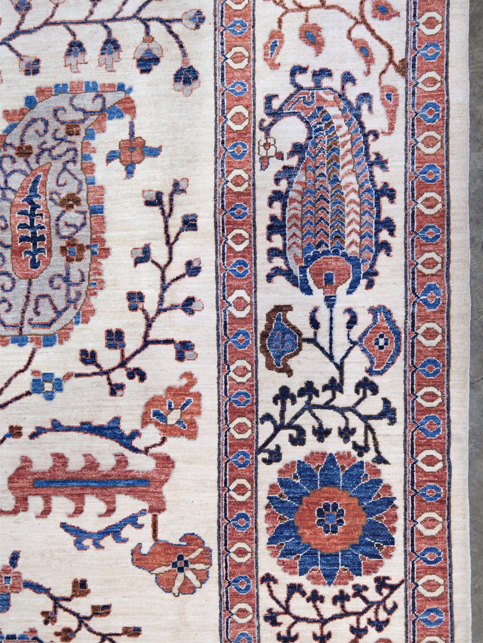 Ivory Suzani style handmade Turkish wool rug with paisley motifs, branching vines, flowers, indigo blue and rust accents, 9x12 from Indigo Rugs Burlingame Bay Area.