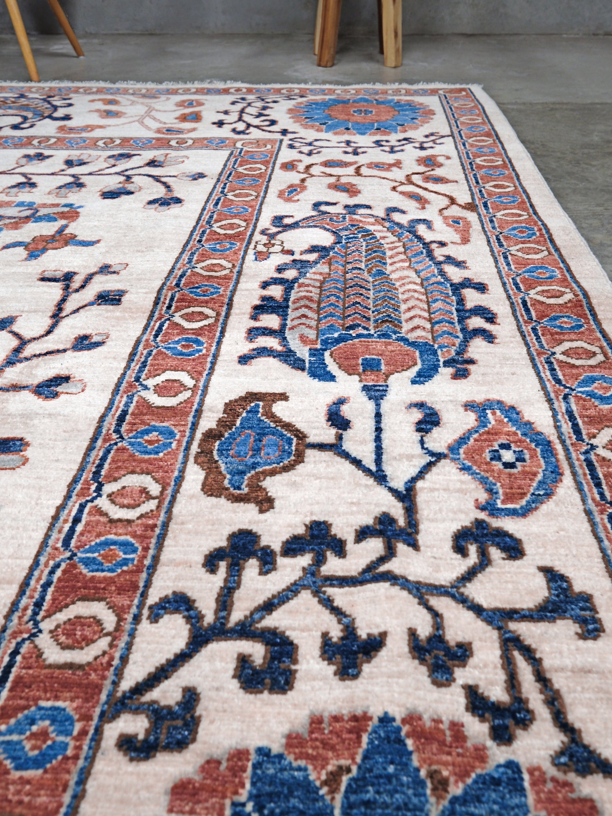 Ivory Suzani style handmade Turkish wool rug with paisley motifs, branching vines, flowers, indigo blue and rust accents, 9x12 from Indigo Rugs Burlingame Bay Area.