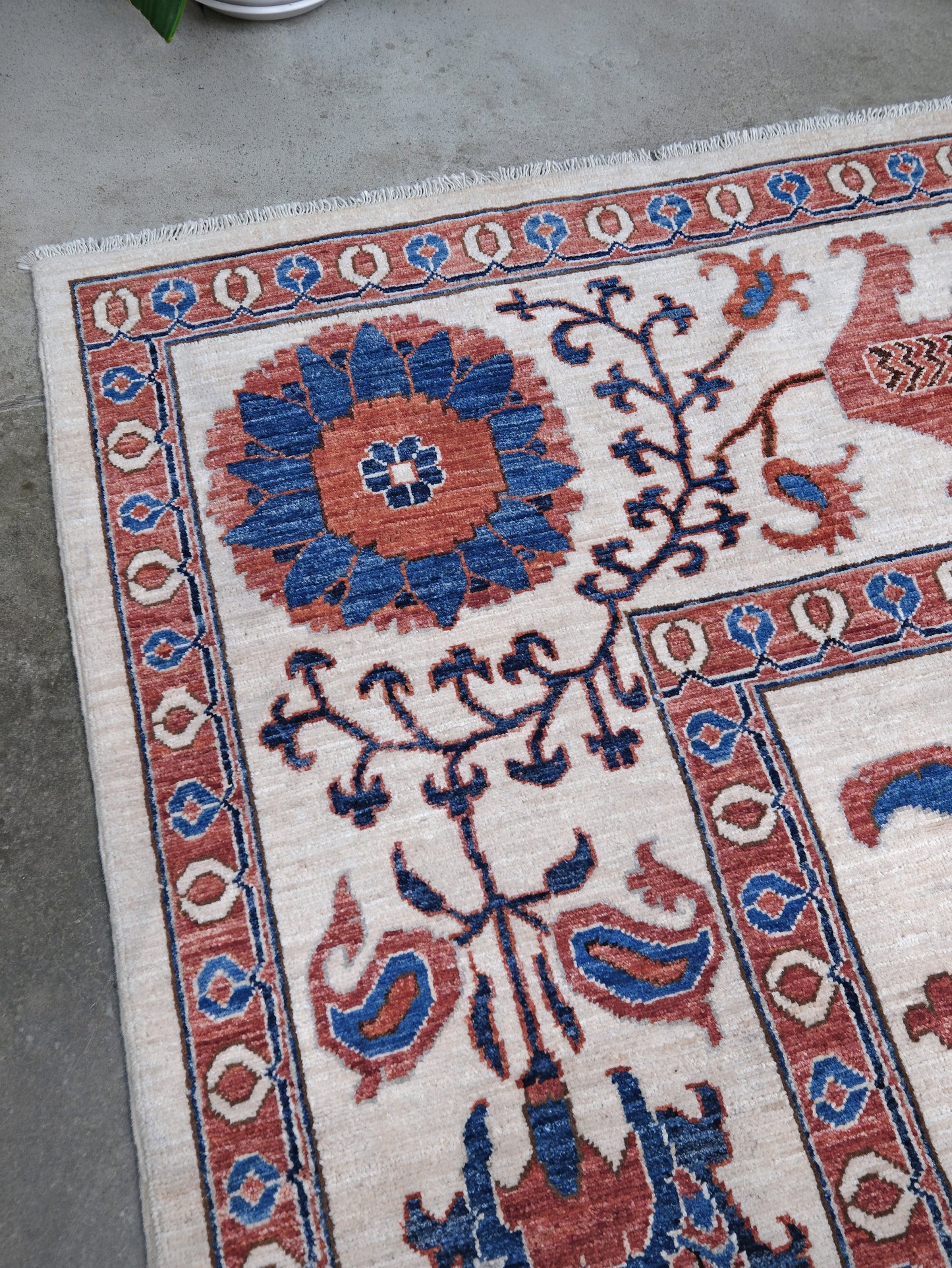 Ivory Suzani style handmade Turkish wool rug with paisley motifs, branching vines, flowers, indigo blue and rust accents, 9x12 from Indigo Rugs Burlingame Bay Area.