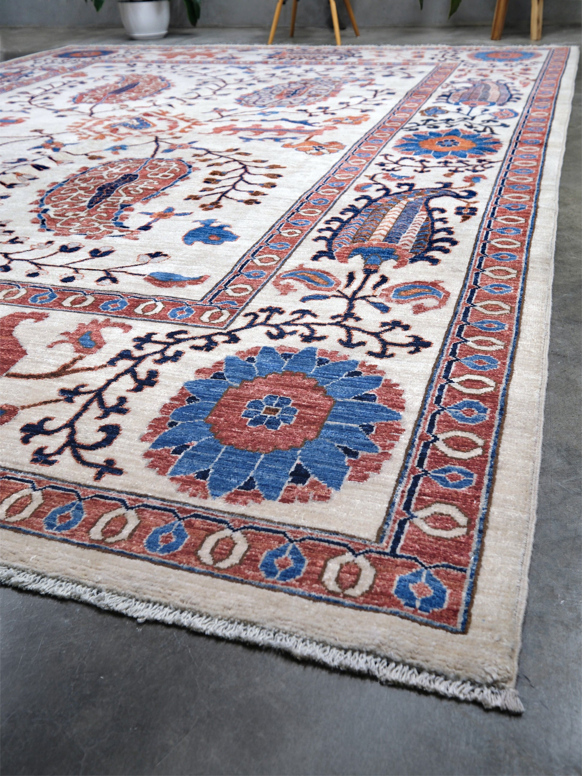 Ivory Suzani style handmade Turkish wool rug with paisley motifs, branching vines, flowers, indigo blue and rust accents, 9x12 from Indigo Rugs Burlingame Bay Area.